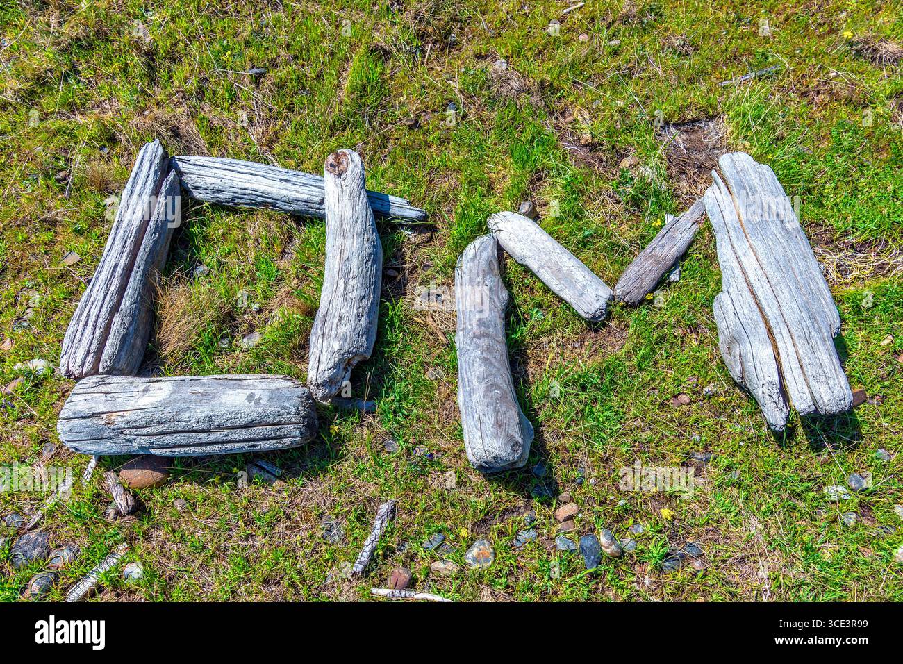 Letters spelling the "OM" sacred sound or chant formed from small pieces of driftwood on the shoreline of Hornby Island, British Columbia, Canada. Stock Photo