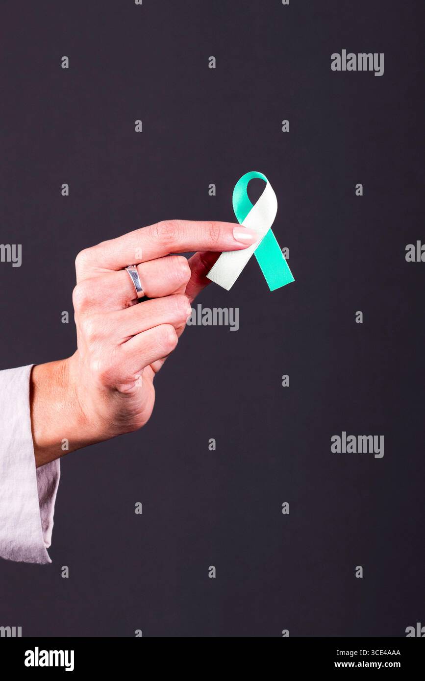 Woman holding teal awareness ribbon hi-res stock photography and images ...