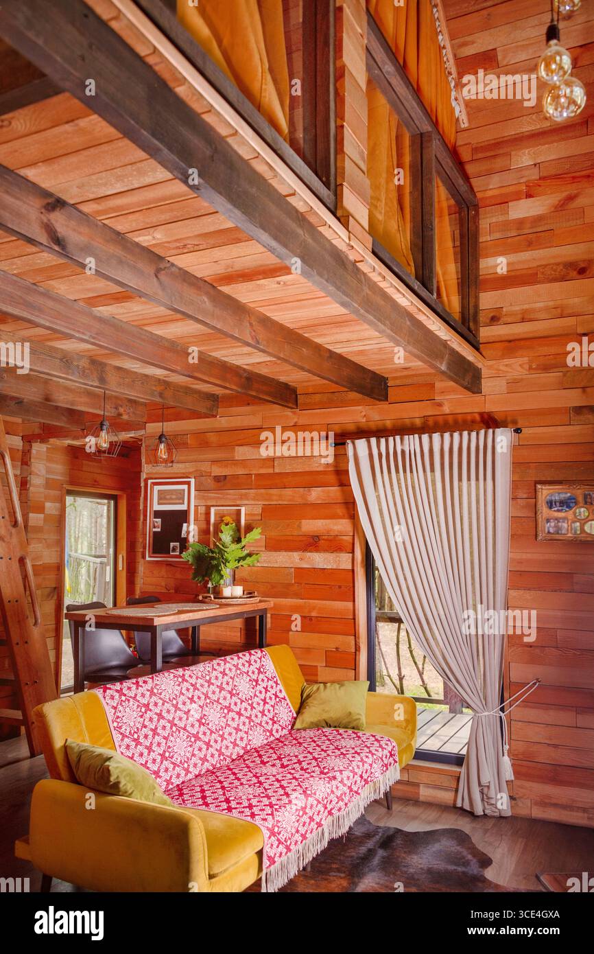 Cabin interior with natural wood panels, wicker accents, and soft ...