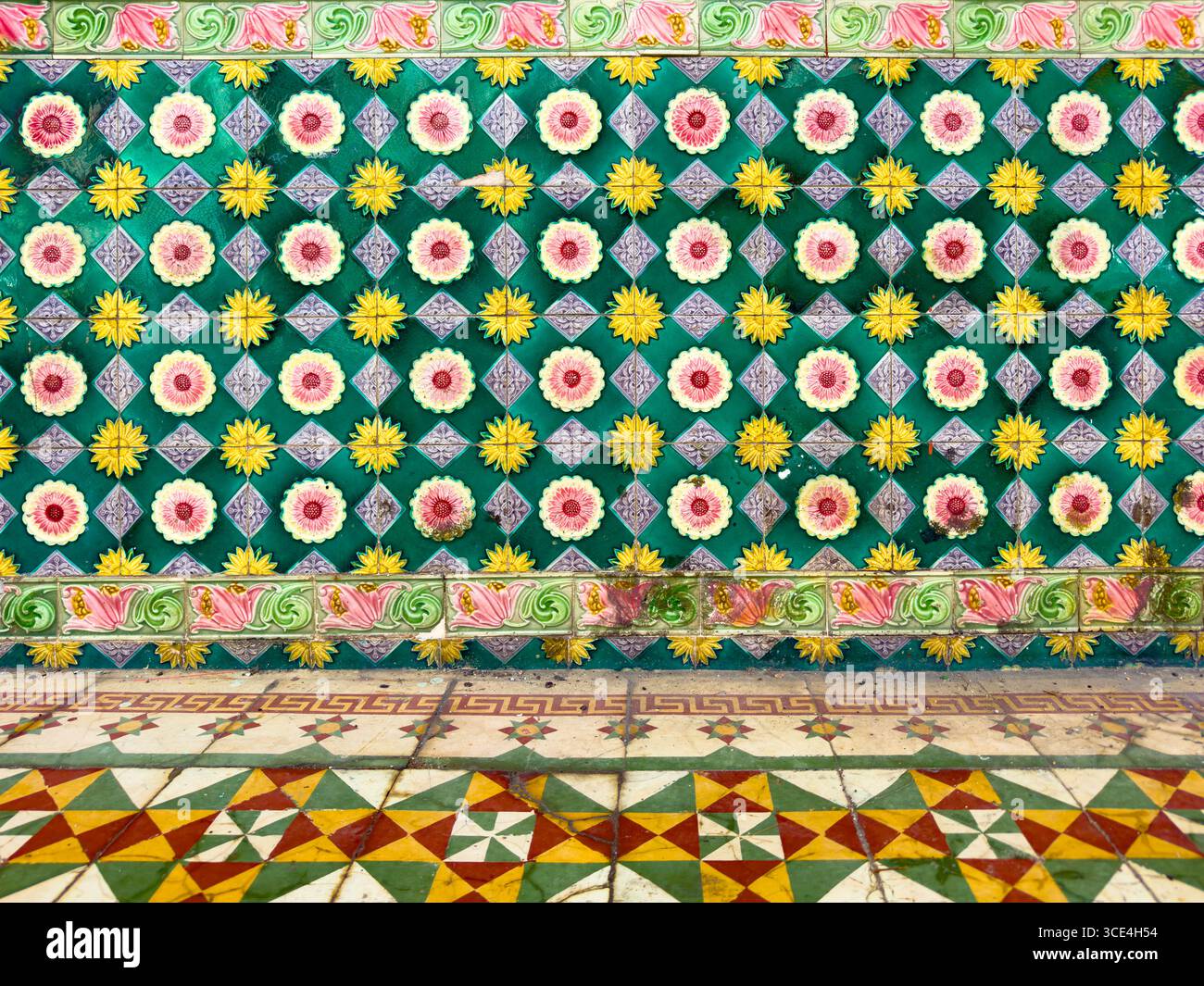Colorful tiled floor and wall featuring vibrant geometric patterns and floral motifs in a traditional design - Smartphone Captured Stock Image