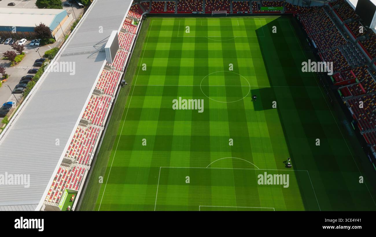 LONDON, UK - AUGUST 5, 2025 - Groundskeepers are working on the lush green pitch of Gtech Community Stadium in London, home of Brentford FC, in prepar Stock Photo