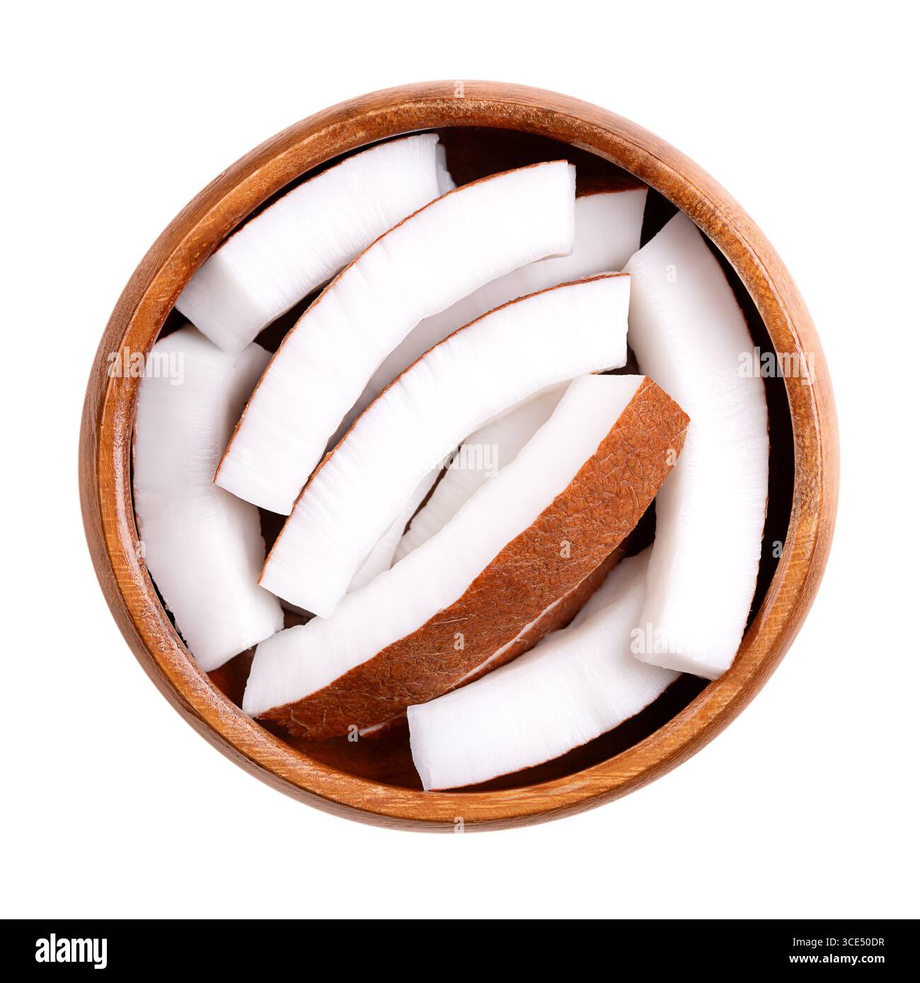 Raw coconut meat, in a wooden bowl. Opaque white flesh of a fresh and young coconut, cut into strips, and ready to eat. Stock Photo