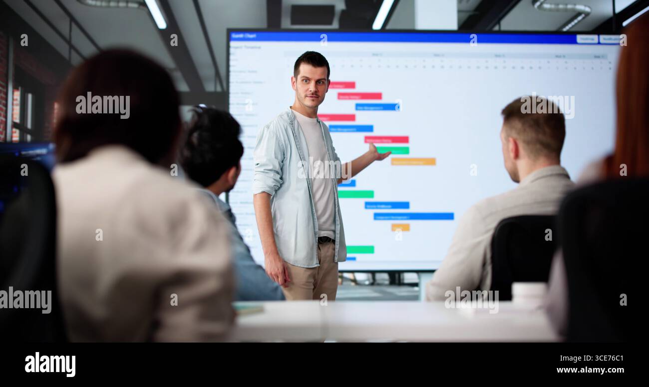 Multicultural Young Team Using Gantt Chart In Corporate Training Session Stock Photo