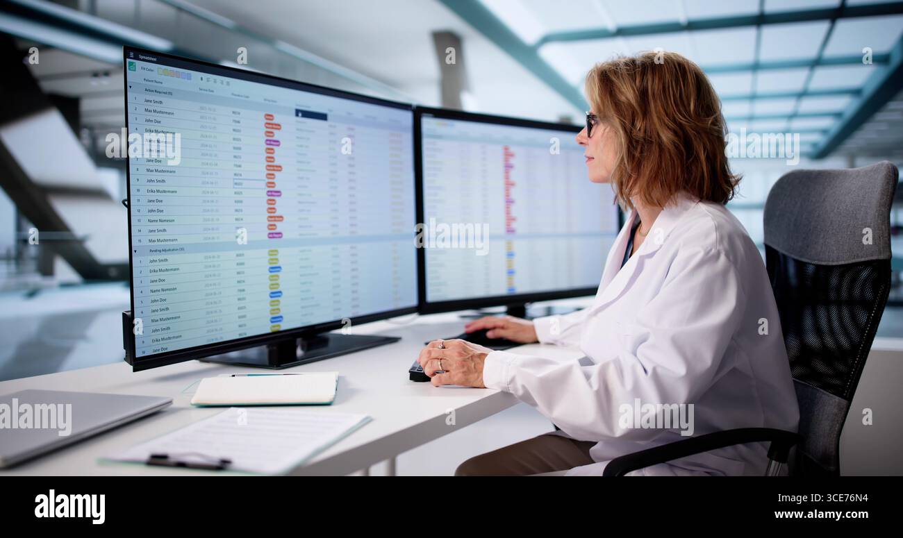 Senior Nurse Using Clinical Coding On Computer For Medical Billing Stock Photo
