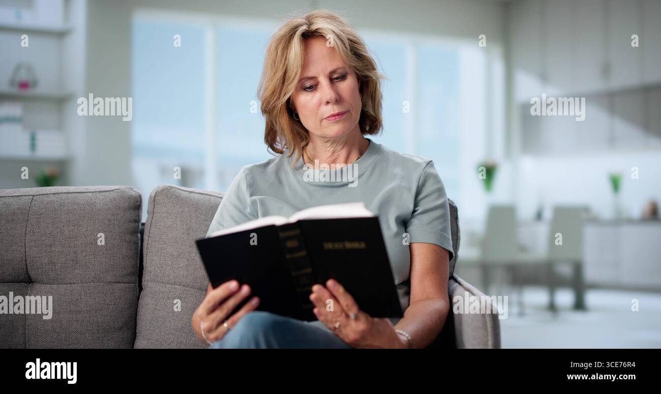Woman Reading Bible At Home For Devotional Worship. Possible Professions: Theologian, Missionary, Pastor Stock Photo