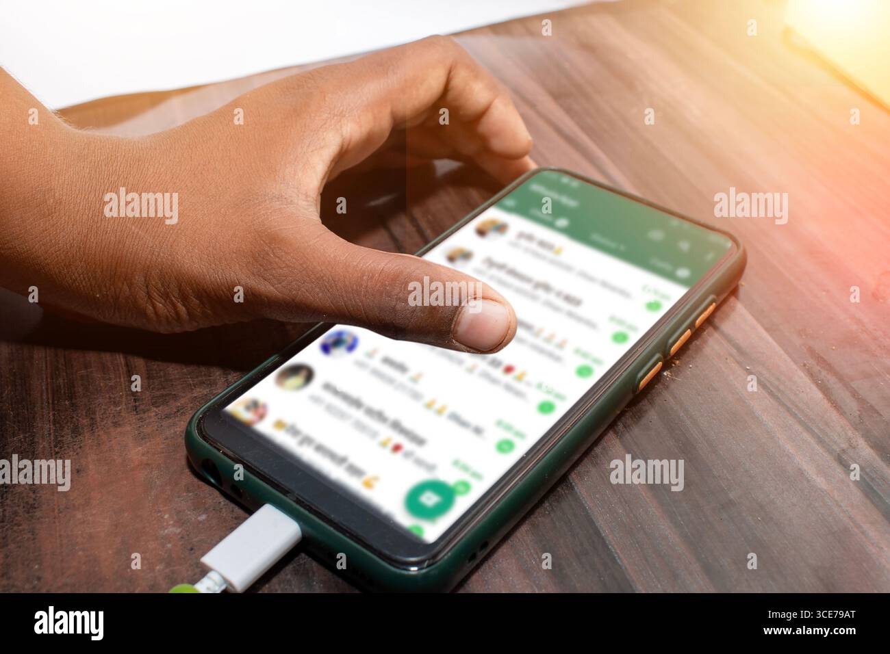 The mobile being used by the hand, The mobile is placed on the table Stock Photo