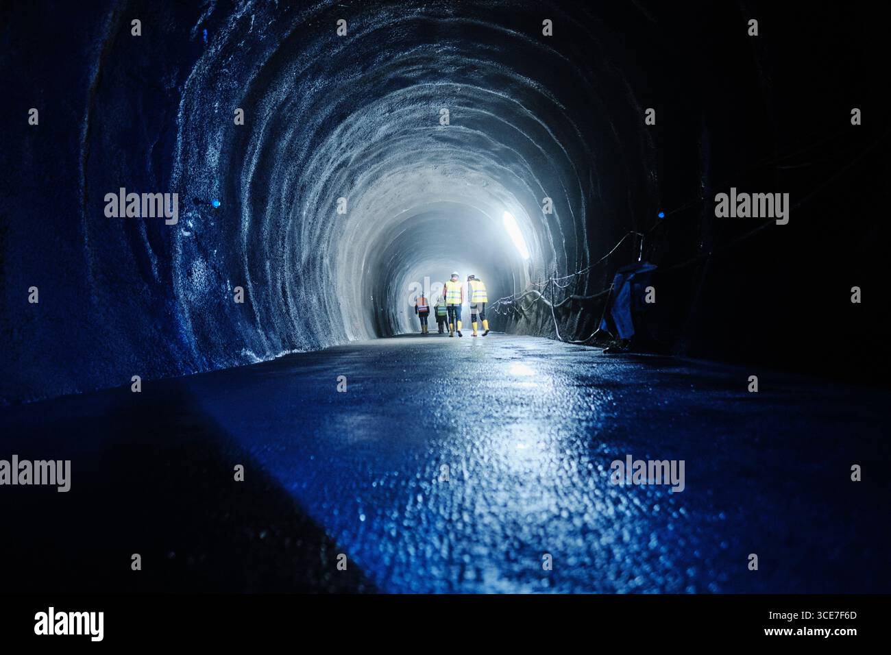 Arbeiter im beleuchteten Wasserstollen Stock Photo