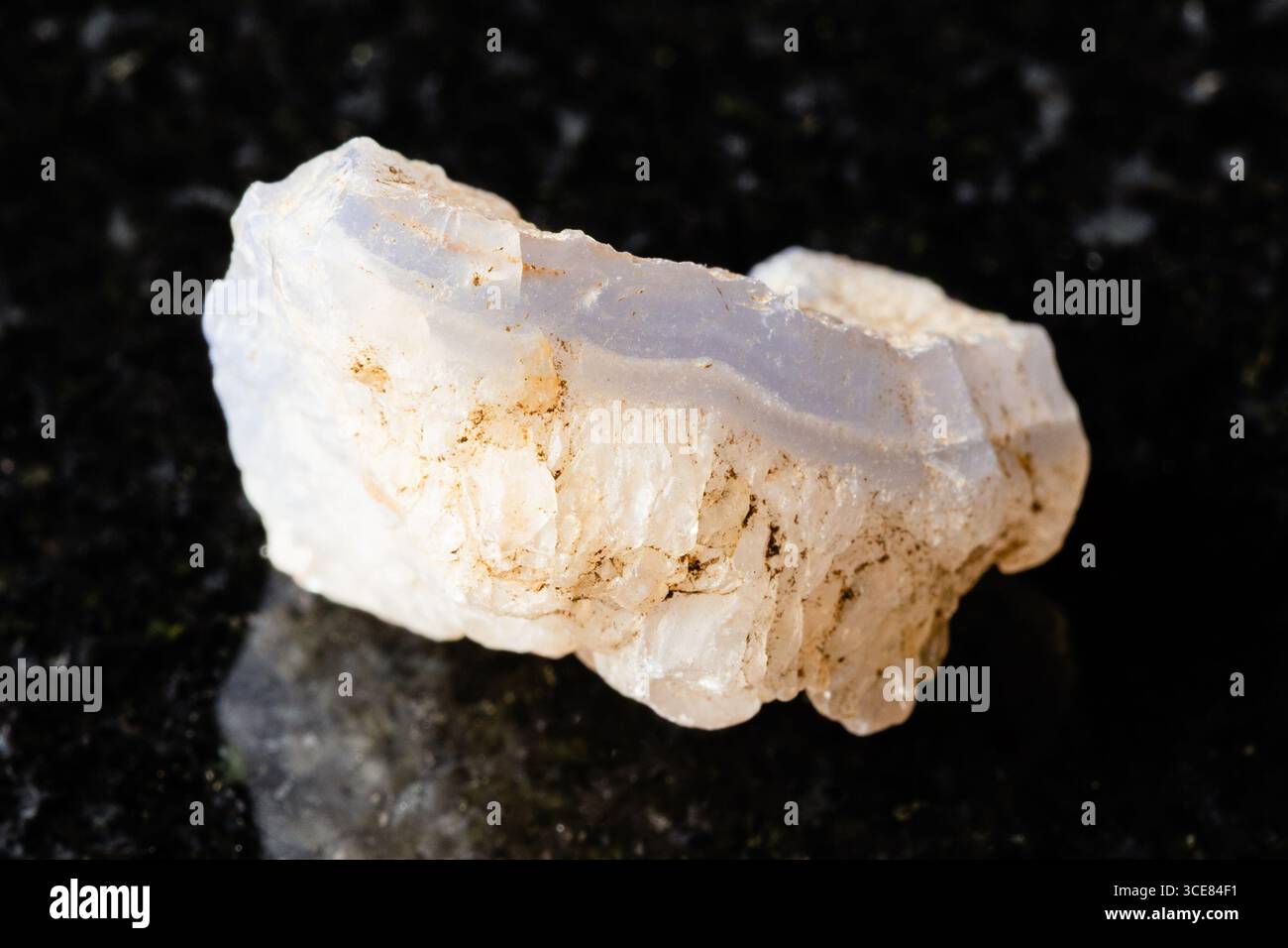sample of rough blue agate rock on black granite background close up from Uzbekistan Stock Photo