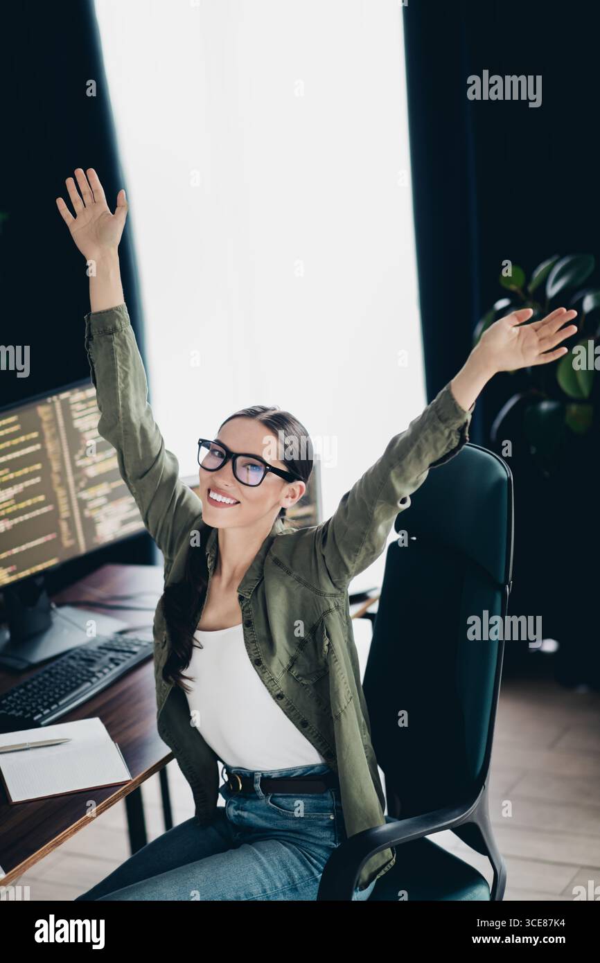 Professional computer programmer enjoying success while working remotely in a home office environment with a computer setup Stock Photo