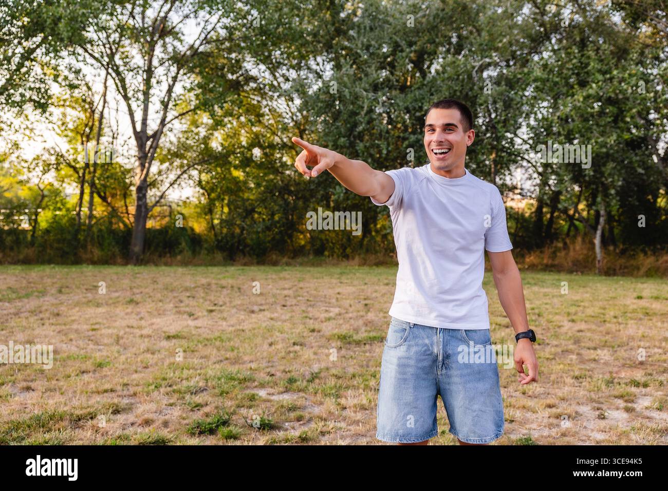 Young man pointing and laughing in a park Stock Photo