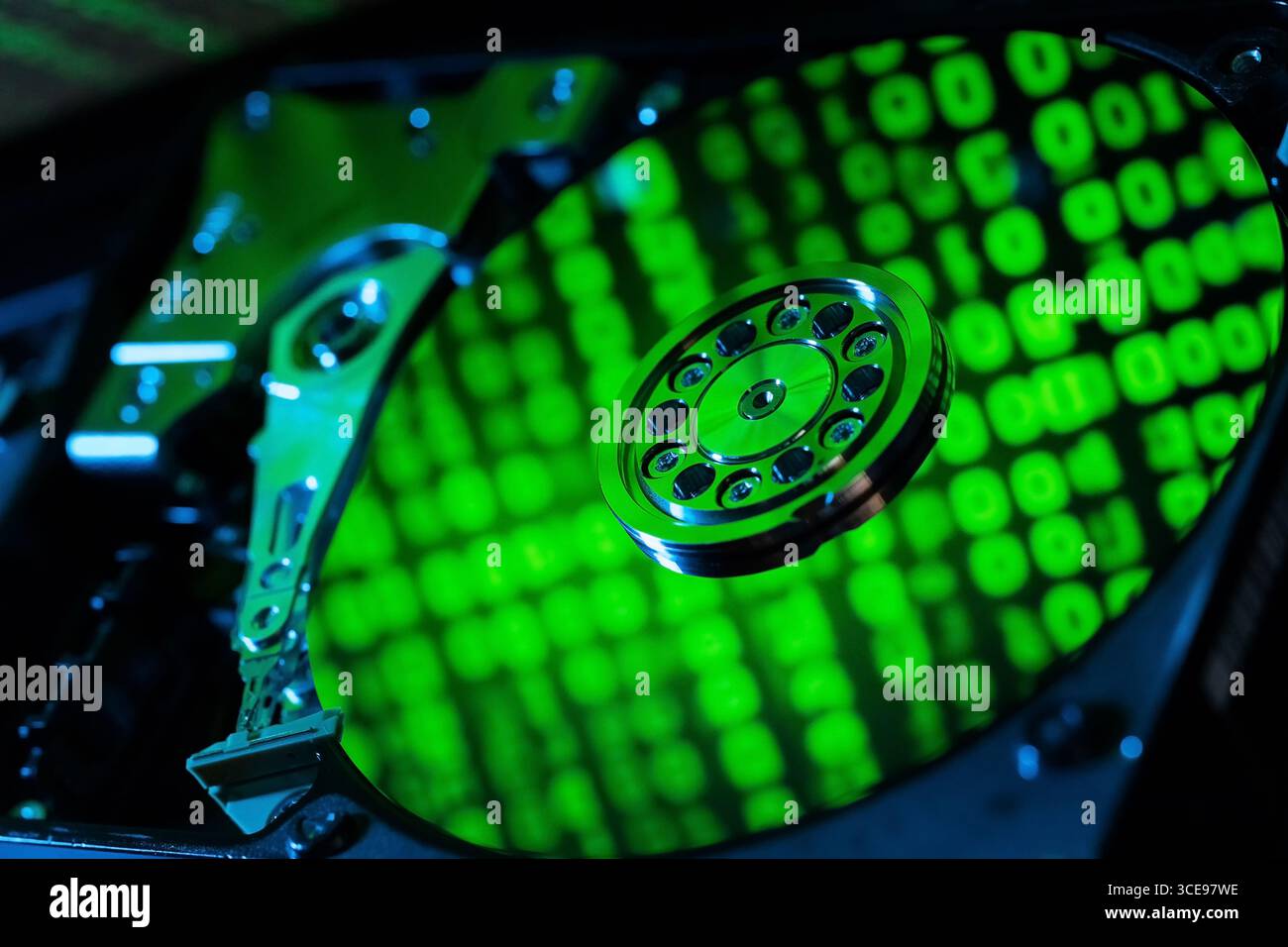 moving hard drive head with green data on drive Stock Photo