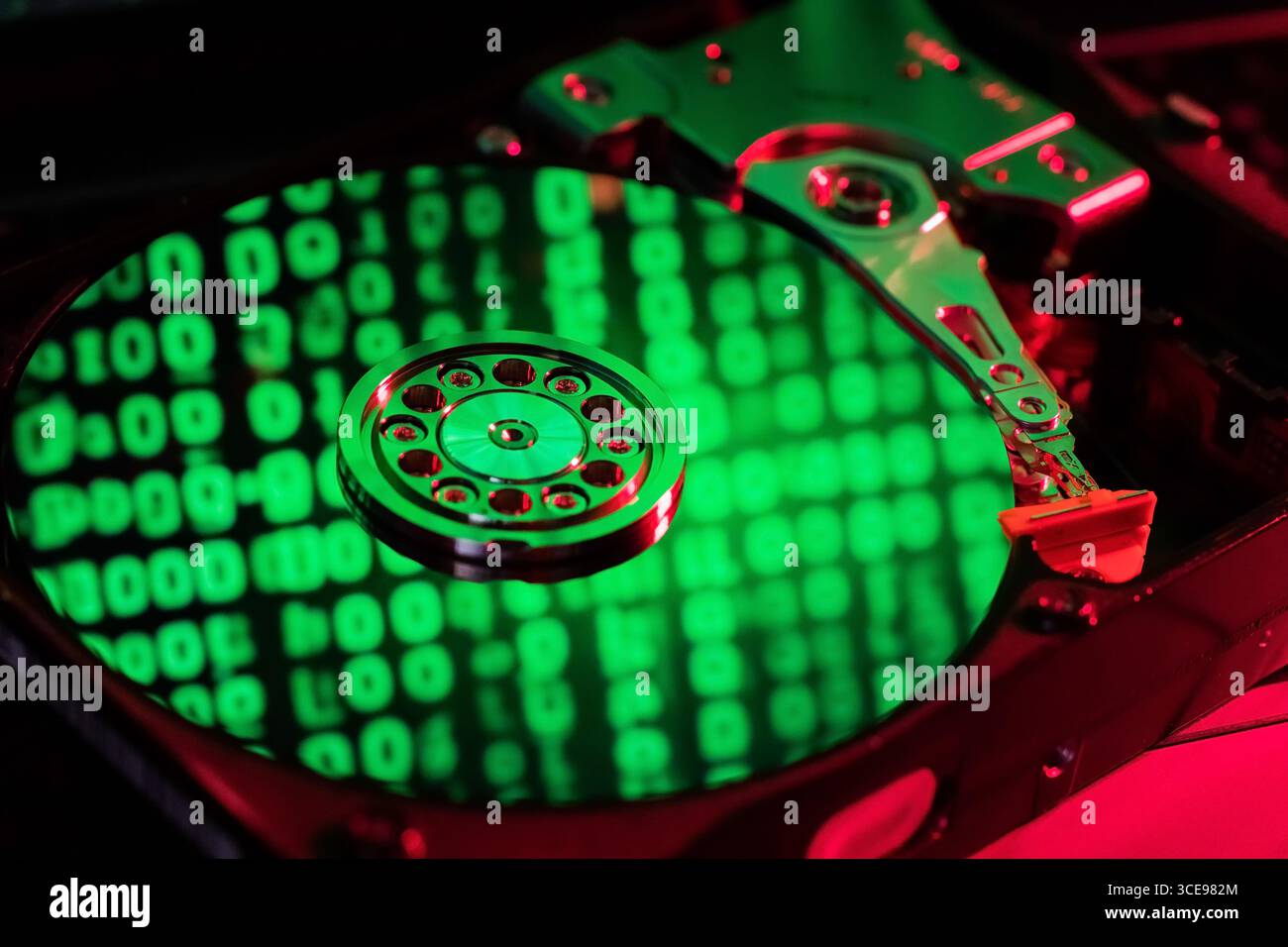 moving hard drive head with green data on drive Stock Photo