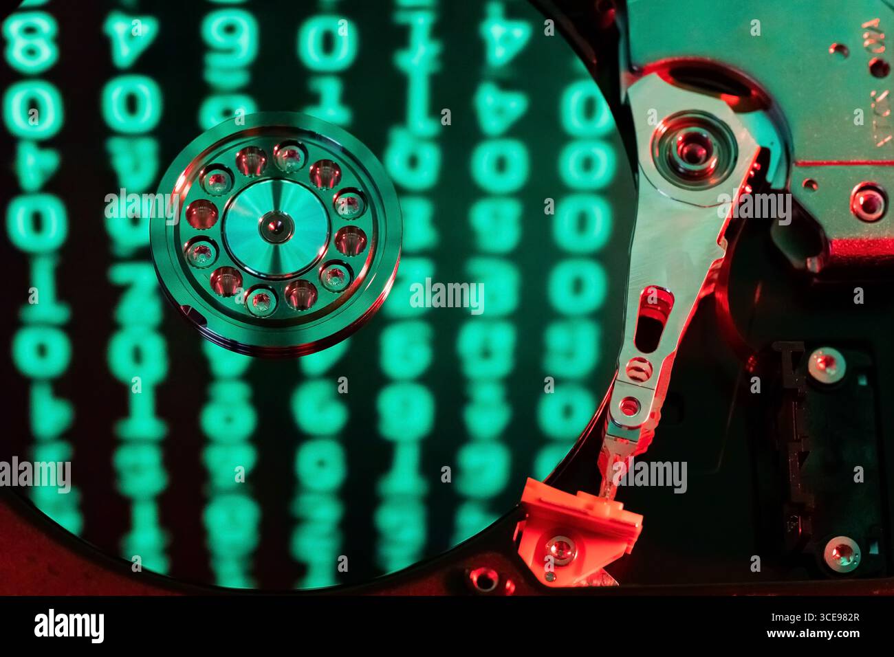 moving hard drive head with green data on drive Stock Photo