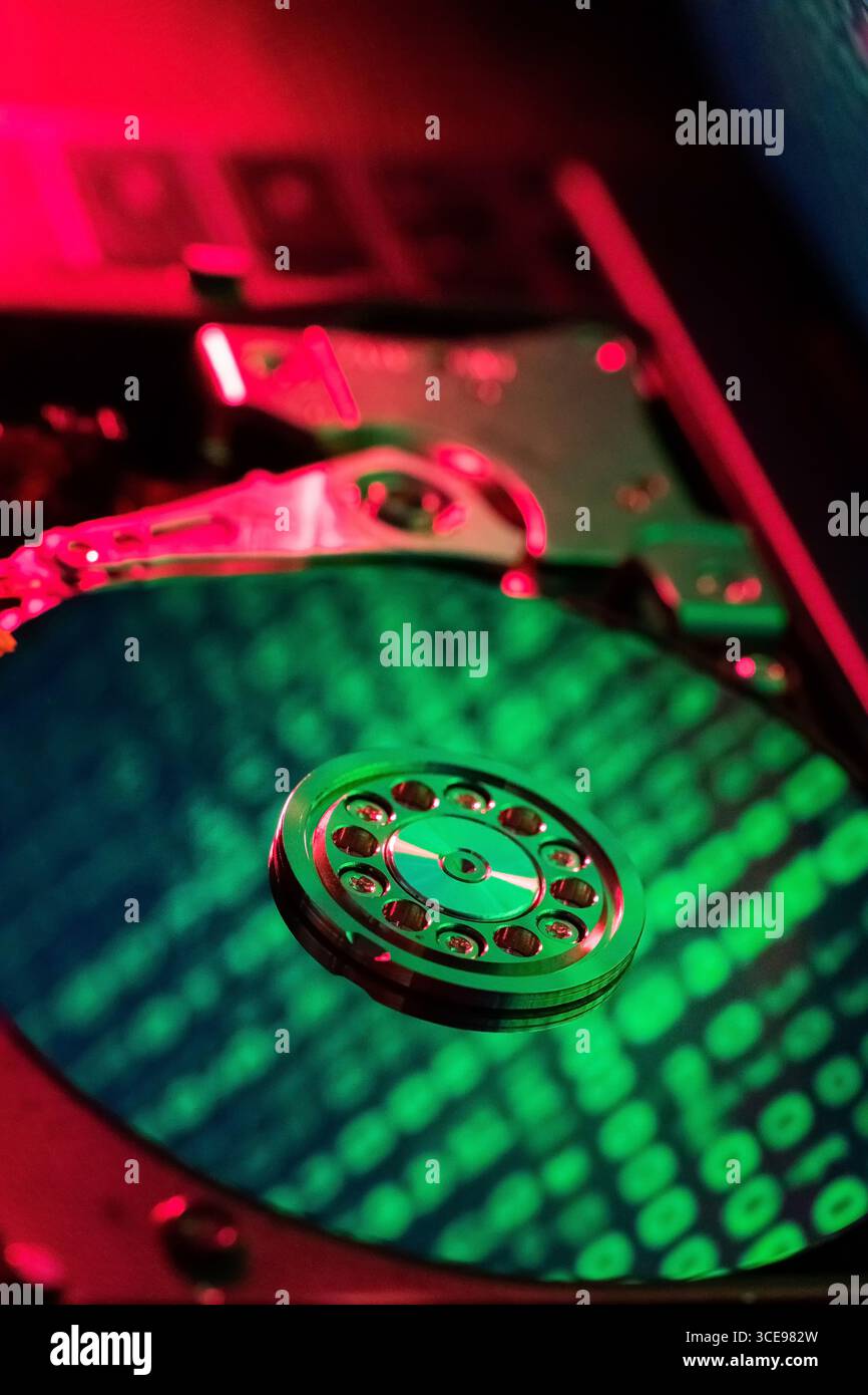 moving hard drive head with green data on drive Stock Photo