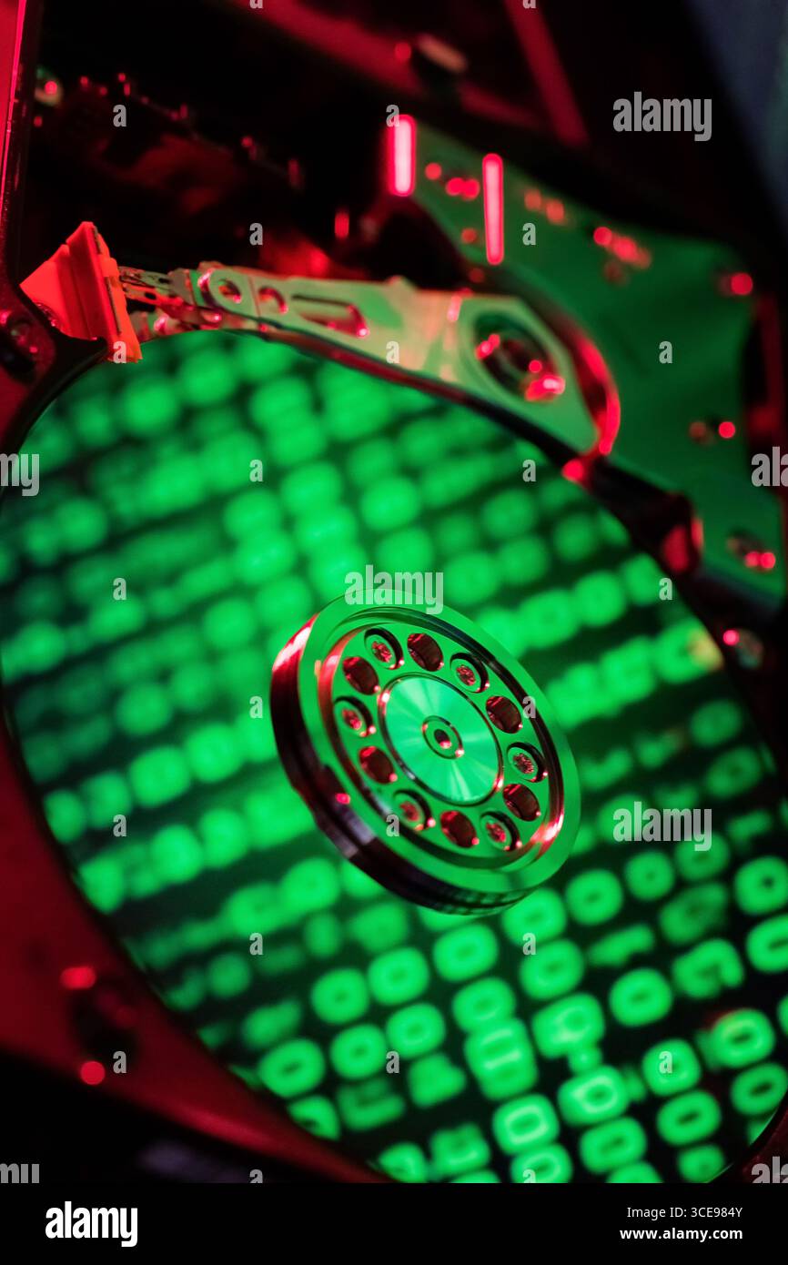 The computer code is displayed in green numbers on the open hard disk Stock Photo