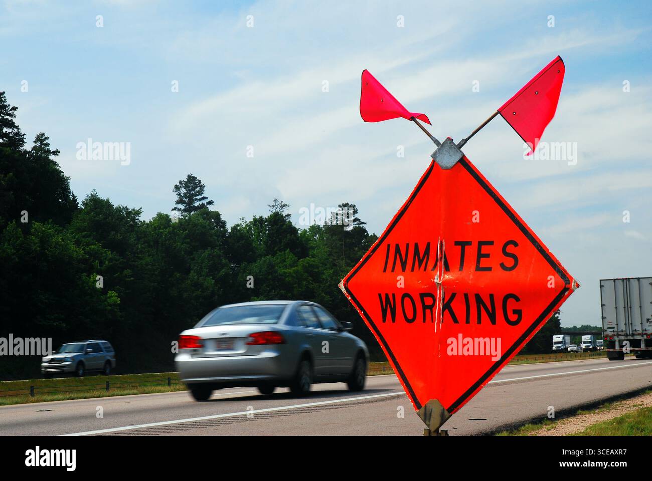 An orange warning sign and flags alert drivers on the interstate to ...
