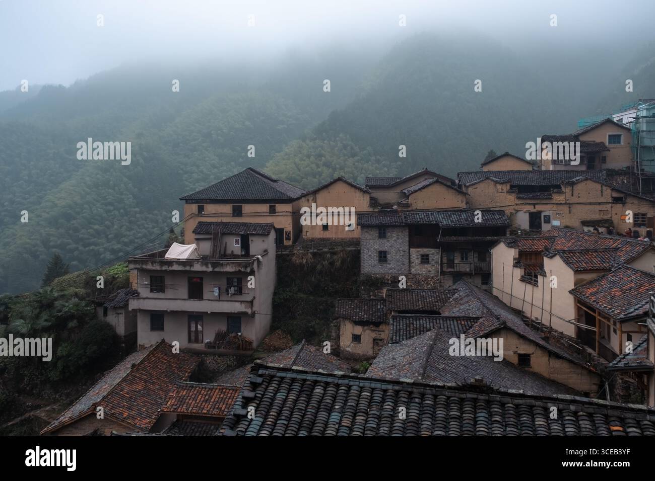 Ancient village showcasing traditional Chinese architecture amid misty ...