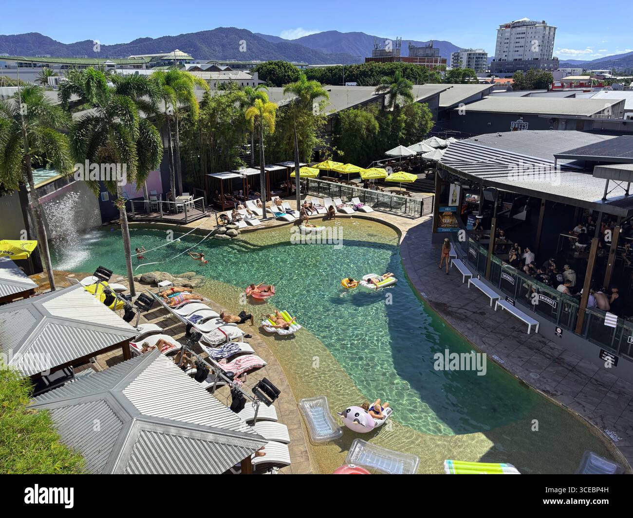 Young travellers in the pool and bar on a fine winter's day at Gilligan's Backpackers Resort, Cairns, Queensland, Australia. No MR or PR - Smartphone Captured Stock Image