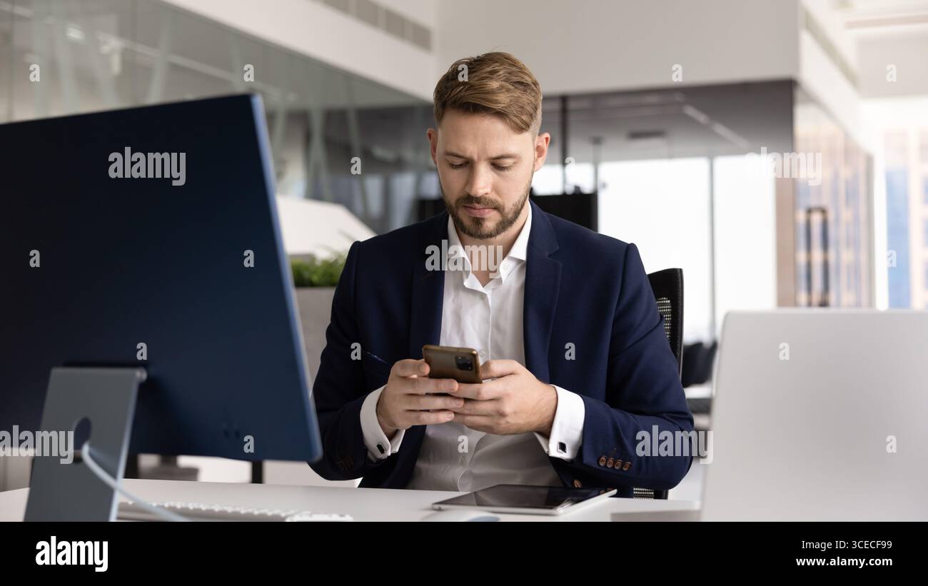 Focused young CEO man using modern Internet technology at workplace Stock Photo