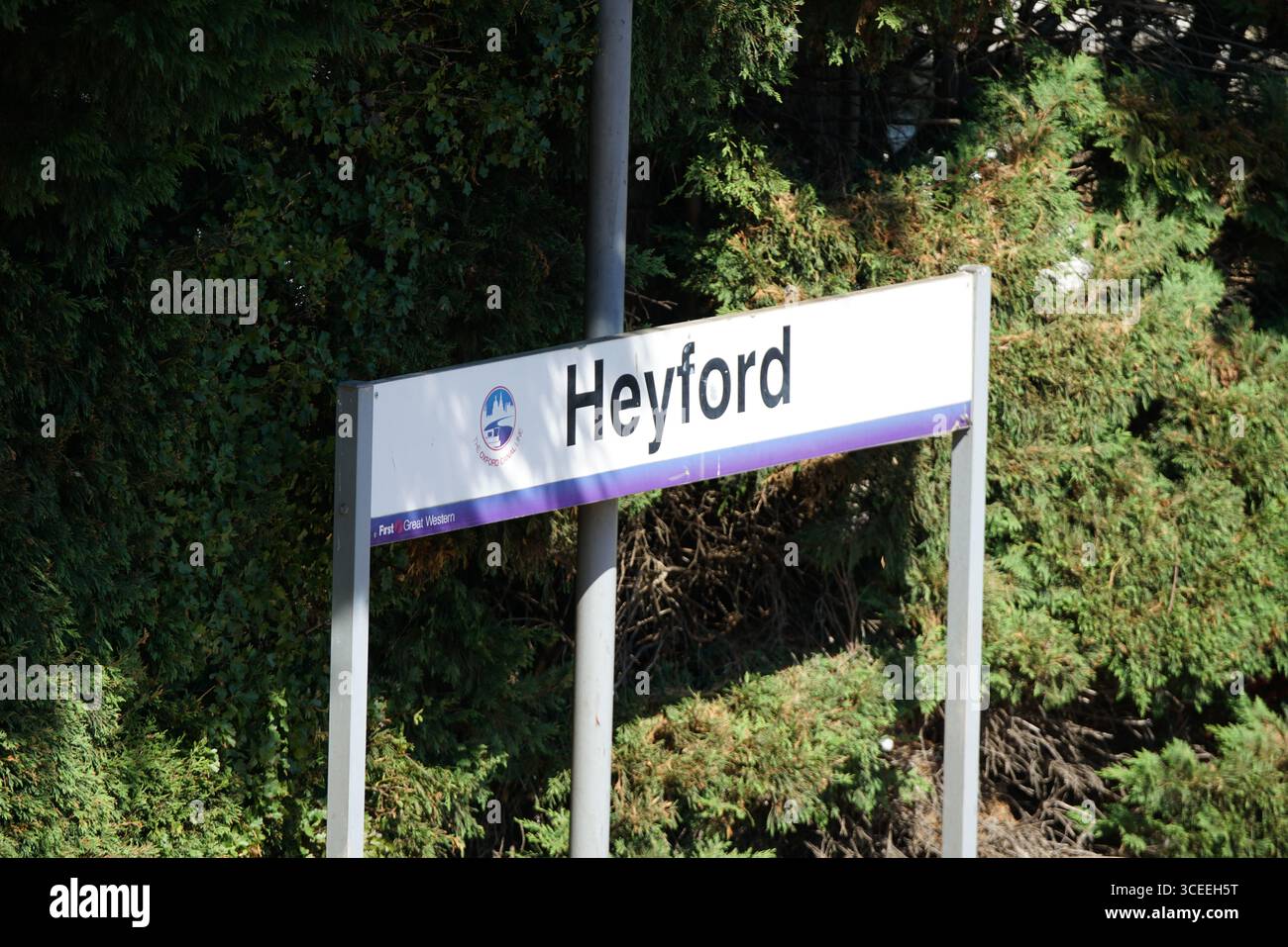 Heyford Train Station Sign Among Greenery in Bright Daylight. Heyford, England Stock Photo