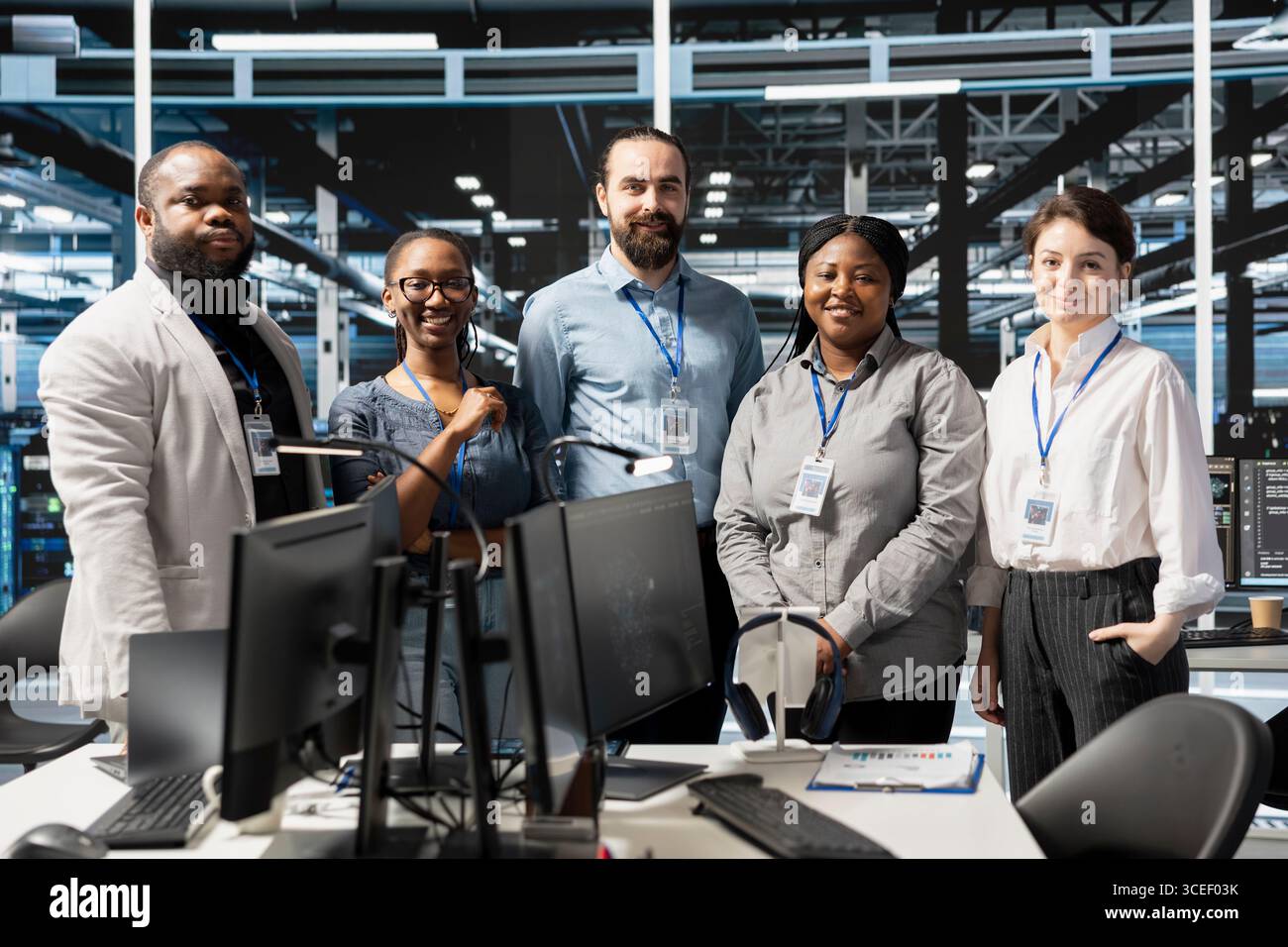 Portrait of cheerful engineering team in data center managing server virtualization, running scripts. Jolly coworkers using programming language in server farm, finetuning network protocols Stock Photo