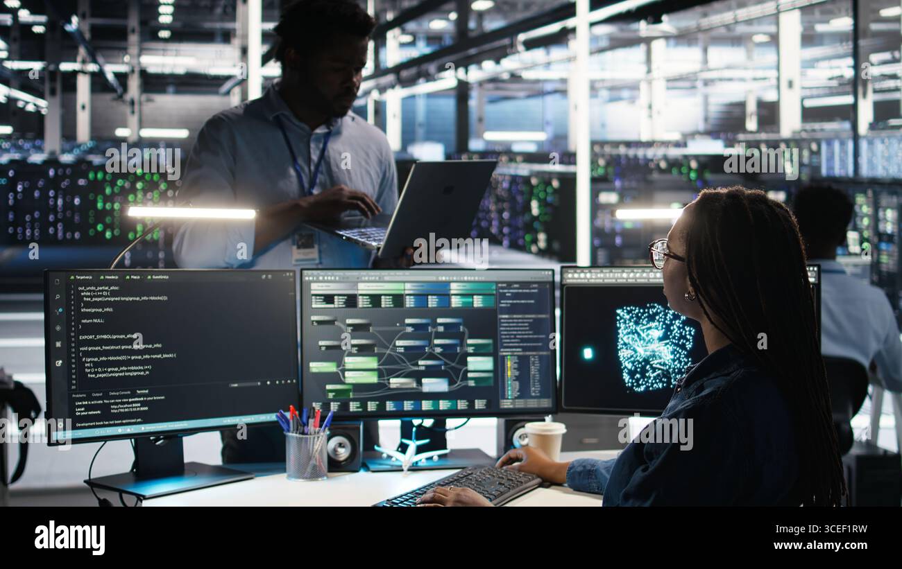 Server farm manager supervising engineer using node tree systems to categorize unstructured data. Data center supervisor overseeing IT expert using natural language processing software, camera A Stock Photo