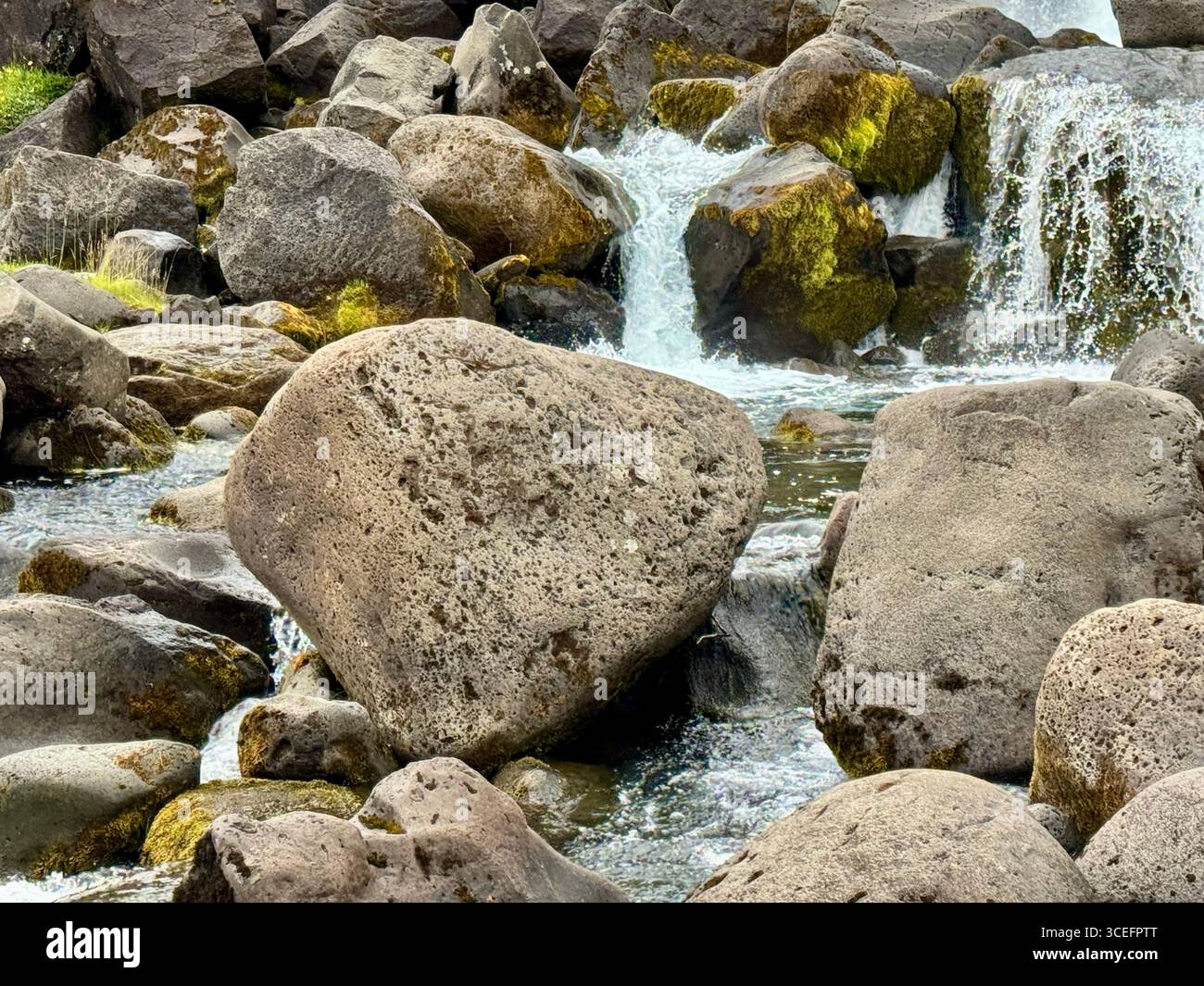 Glacial water cascading over rocks and boulders at the bottom of Oxararfoss waterfall in Thingvellir National Park. - Smartphone Captured Stock Image