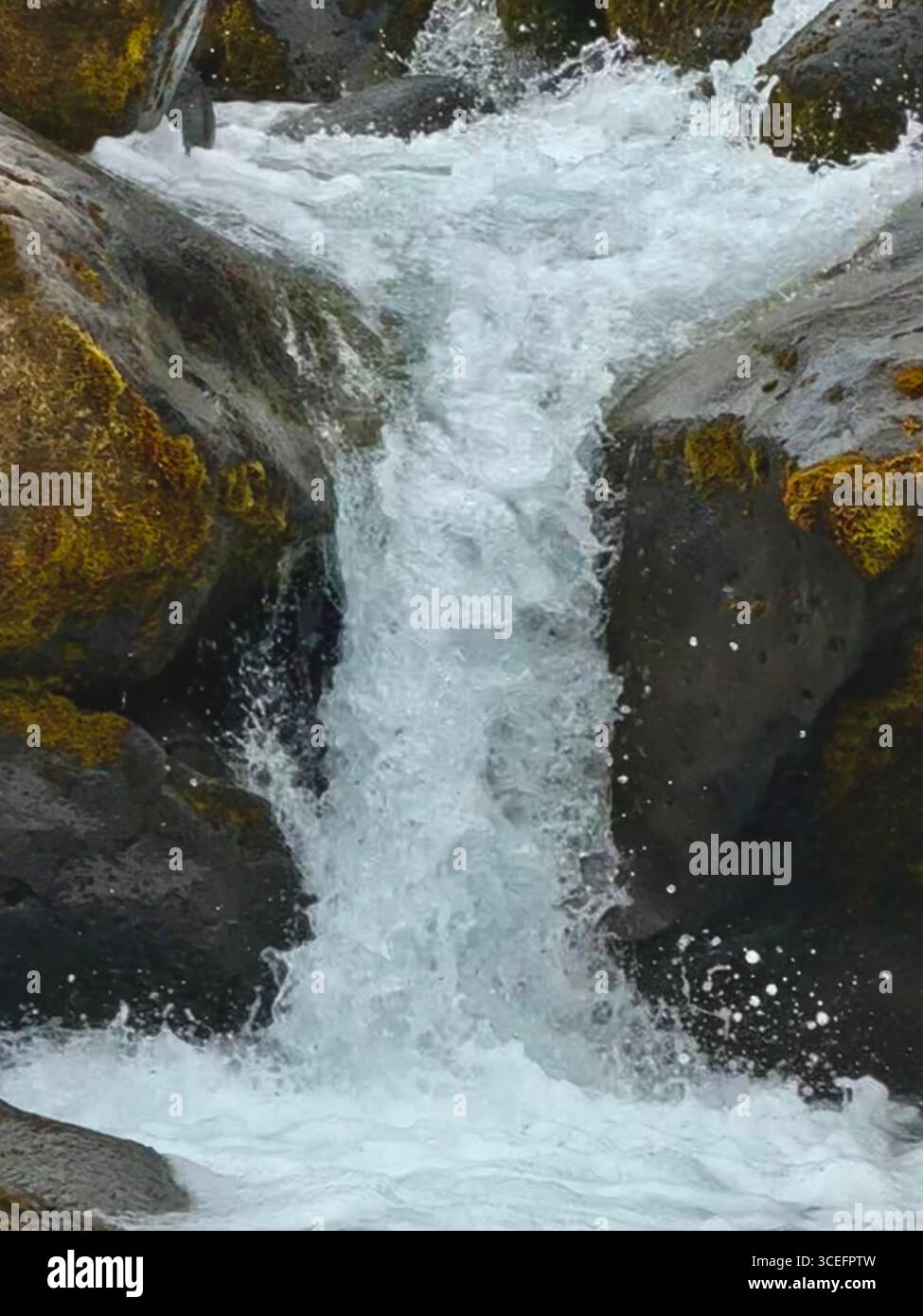 Rushing water pouring down over the rocks at Oxararfoss waterfall. - Smartphone Captured Stock Image