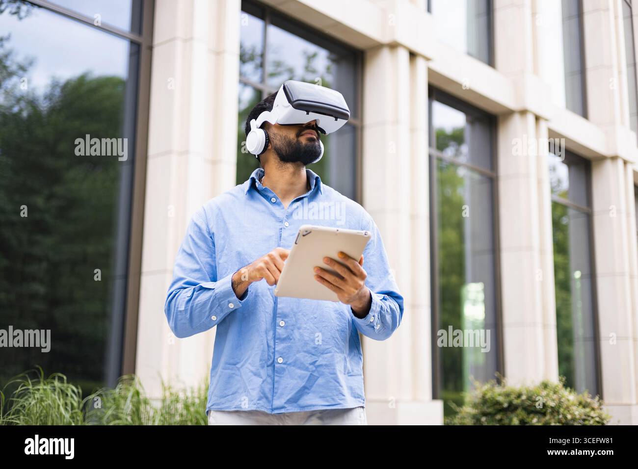 Man Using VR Headset and Tablet Stock Photo