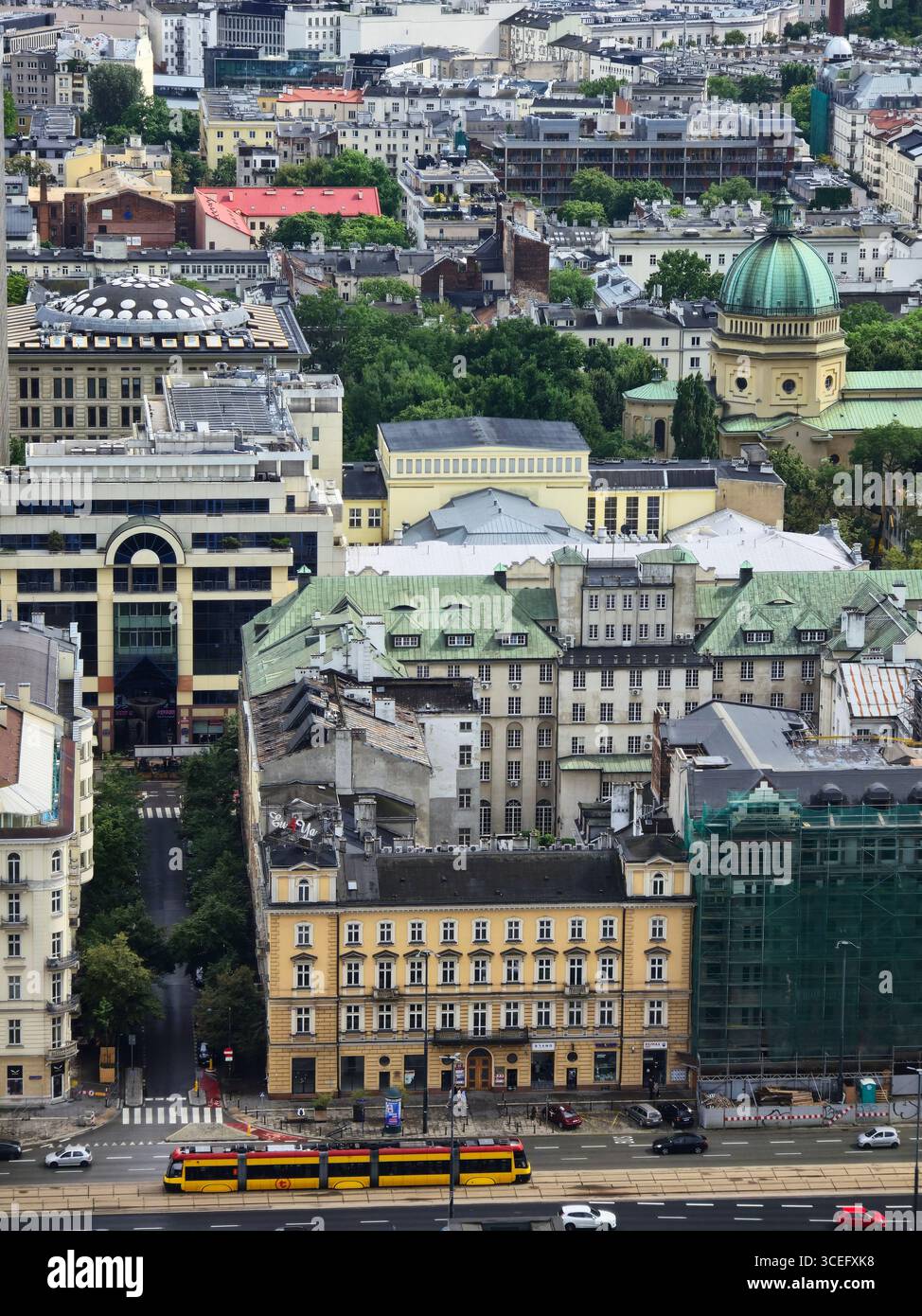 A view of a beutiful historical building on Al. Jerozolimskie 55/11 and the Roman Catholic Parish of St. Barbara behind it in Warsaw, Poland. - Smartphone Captured Stock Image