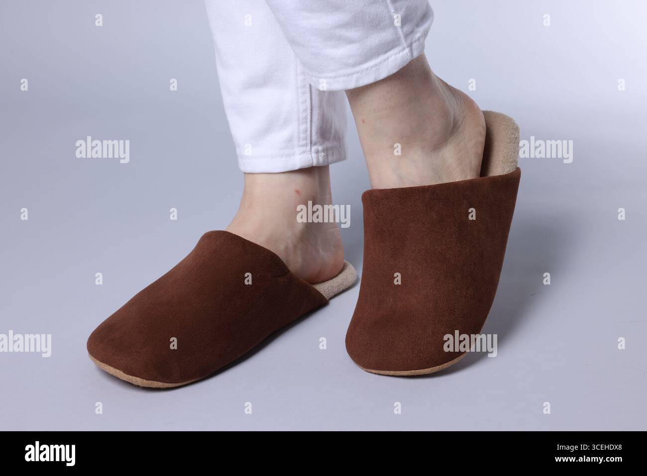 Woman in soft brown slippers on grey background, closeup Stock Photo ...