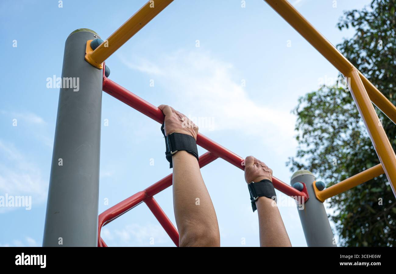 Man doing pull ups workout on the steel bar using a wrist grip. Close up view. Stock Photo