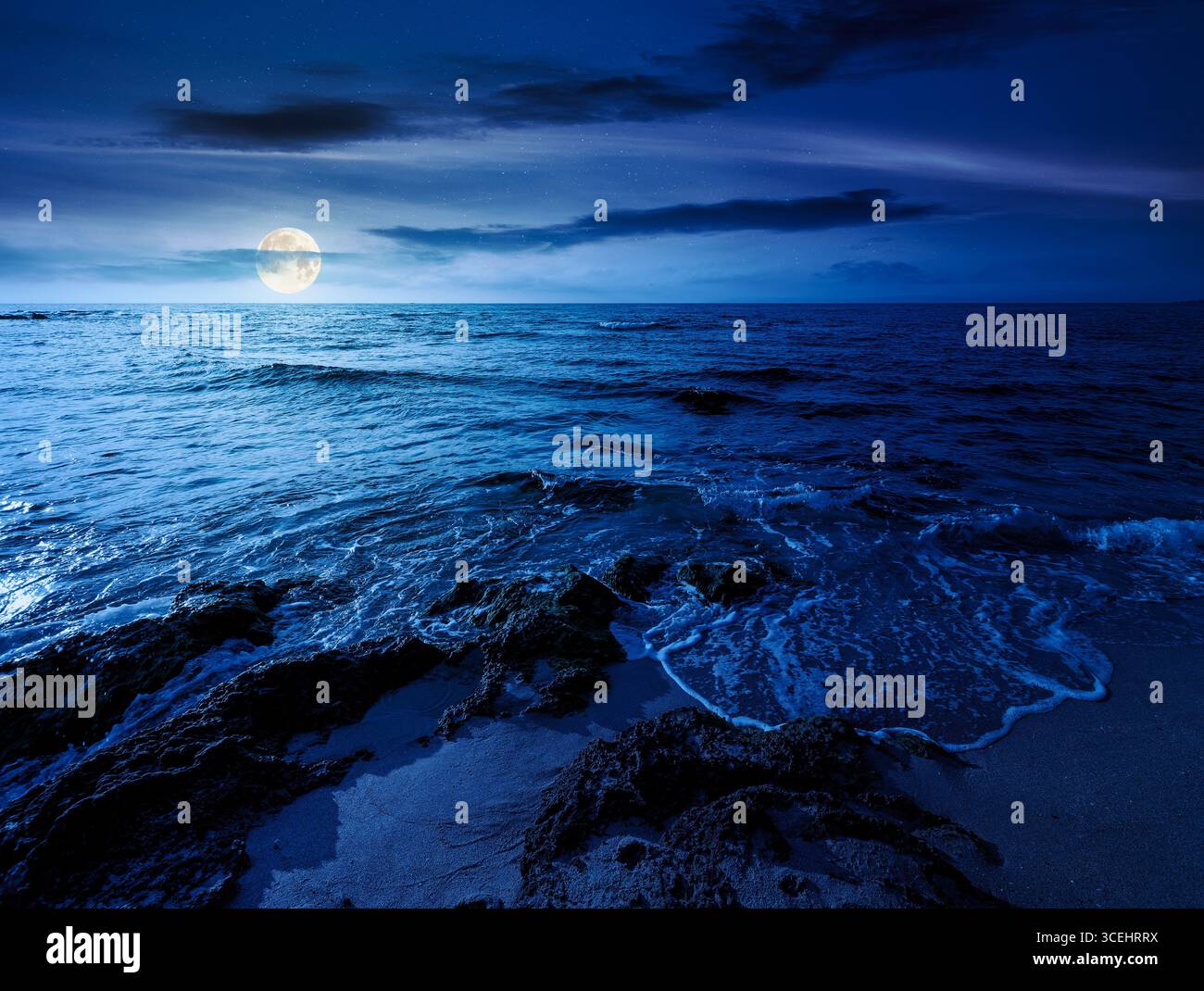 beach with sand at night. summer vacation at the seaside. beautiful seascape with calm waves in full moon light. landscape at the sea under sky with f Stock Photo