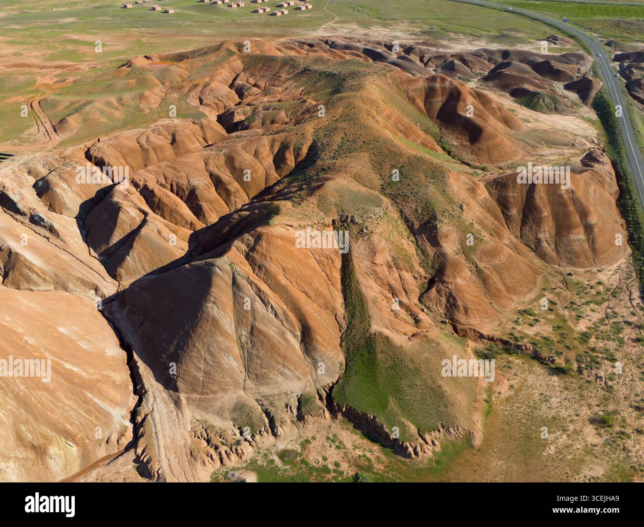 Aerial view of a hilly landscape dominated by ochre-coloured rock ...