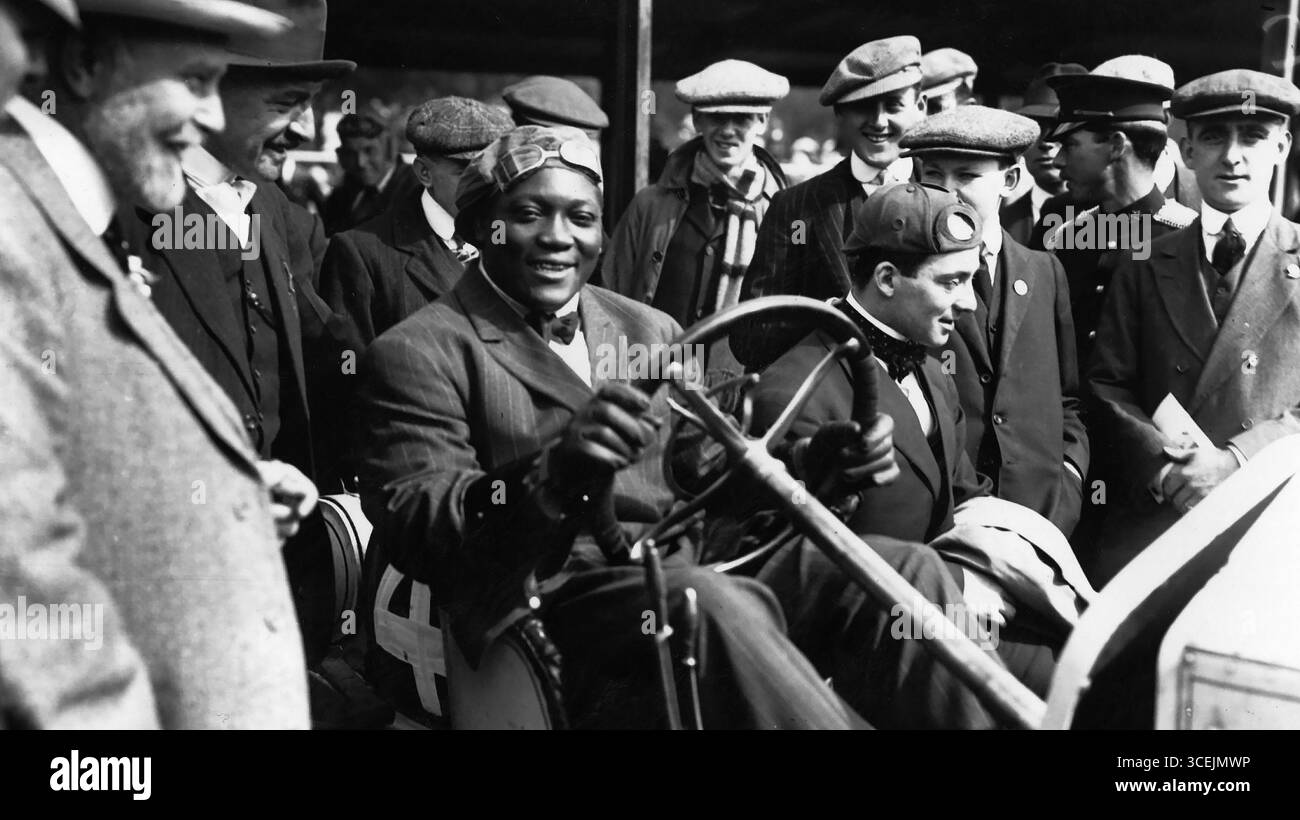 Jack Johnson, the world's first black heavyweight boxing champion, posing inside a car in the early 1900s Stock Photo