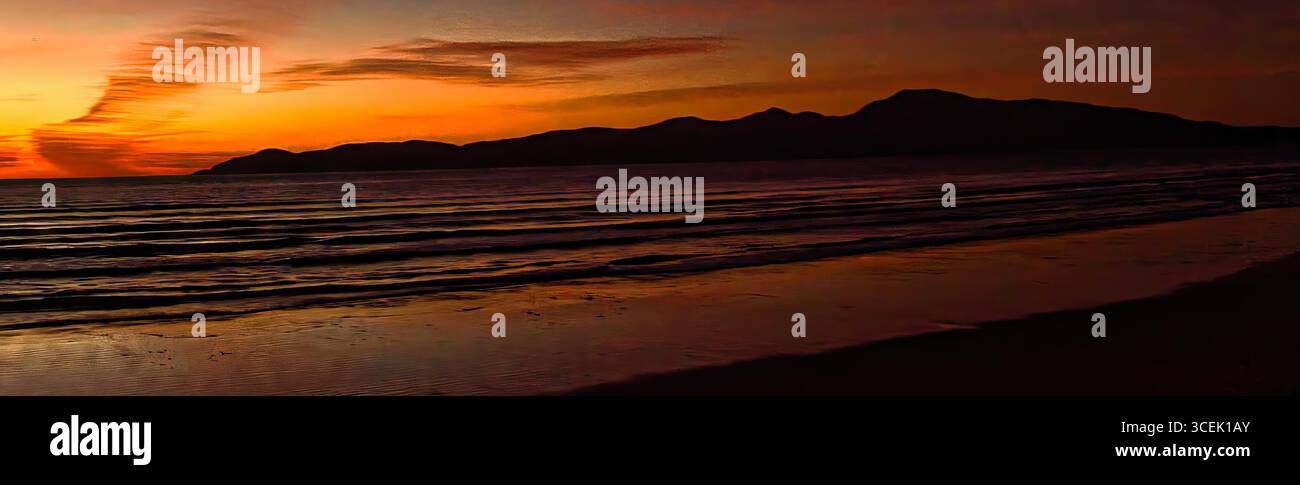 Deep orange sunset sky over kapiti island in Wellington New Zealand with ocean waves Stock Photo