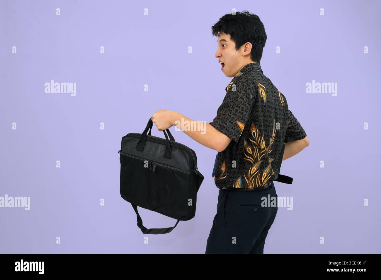 young professional wearing batik shirt with backpack and journal books , office man concept Stock Photo