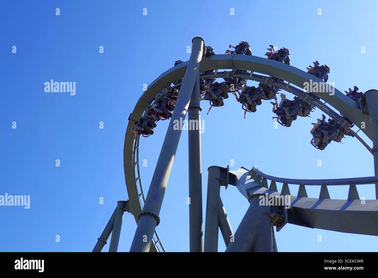 Passengers hanging upside down on inverted roller coaster ride at ...