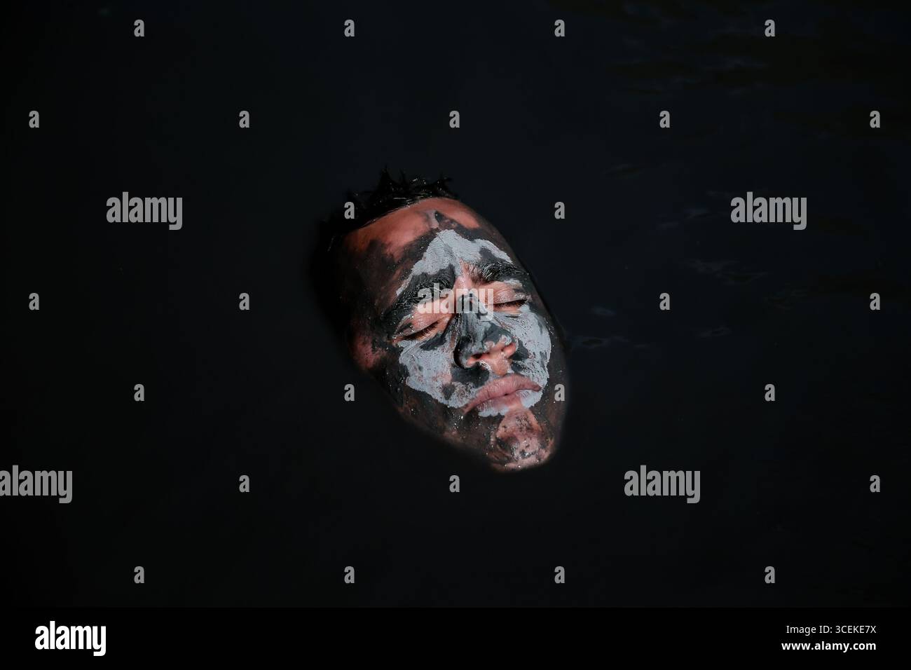 Soufrière, Saint Lucia – December 22, 2015: A man submerged in the volcanic mud pools at the world’s only drive-in volcano. Stock Photo