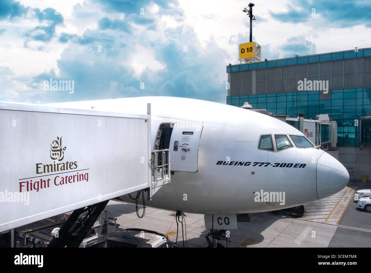 A Boeing 777-300ER aircraft connected to an Emirates Flight Catering service unit at Changi airport terminal Singapore Stock Photo