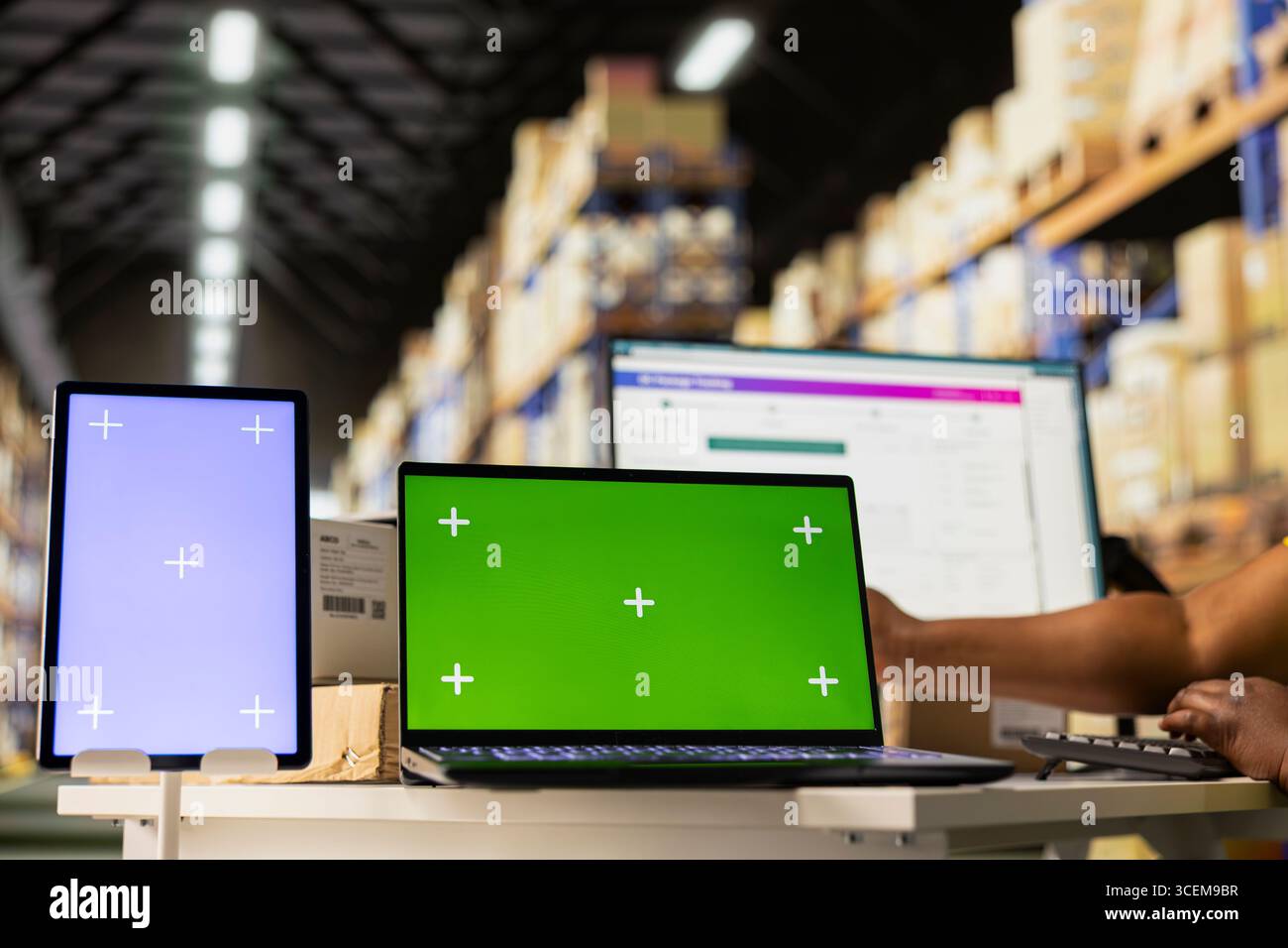 Staff reviews chroma key monitor in the stock room for data entry ...