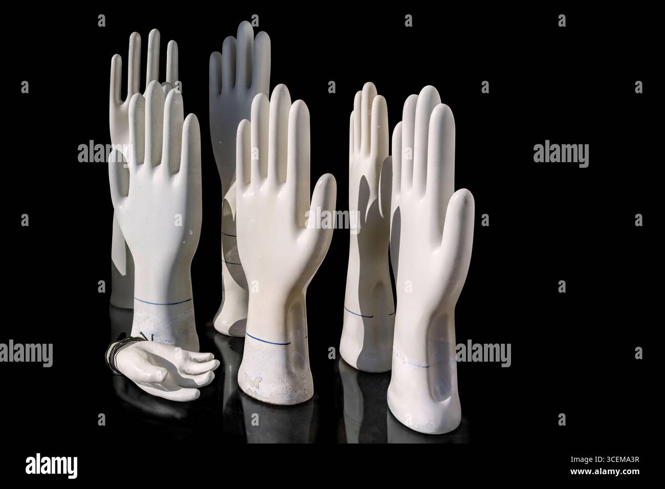 White plaster hands on a black background. Stock Photo