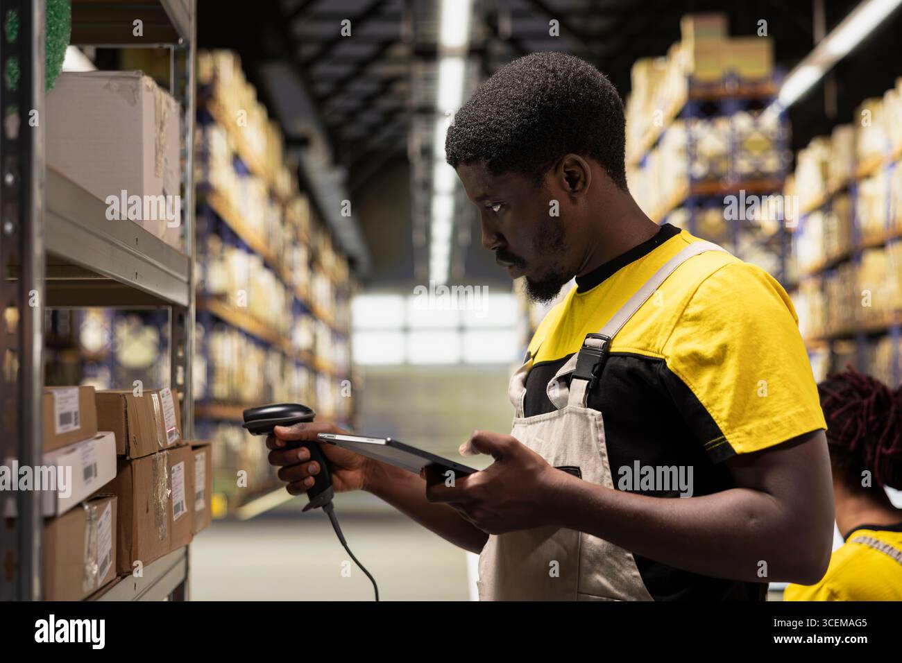 Black staff member using a barcode scanner to process shipping labels ...