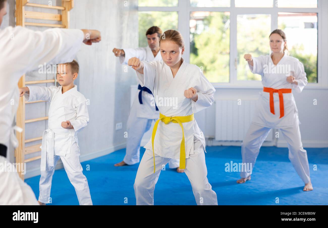 Teen girl with family repeat movements and learn fighting techniques ...