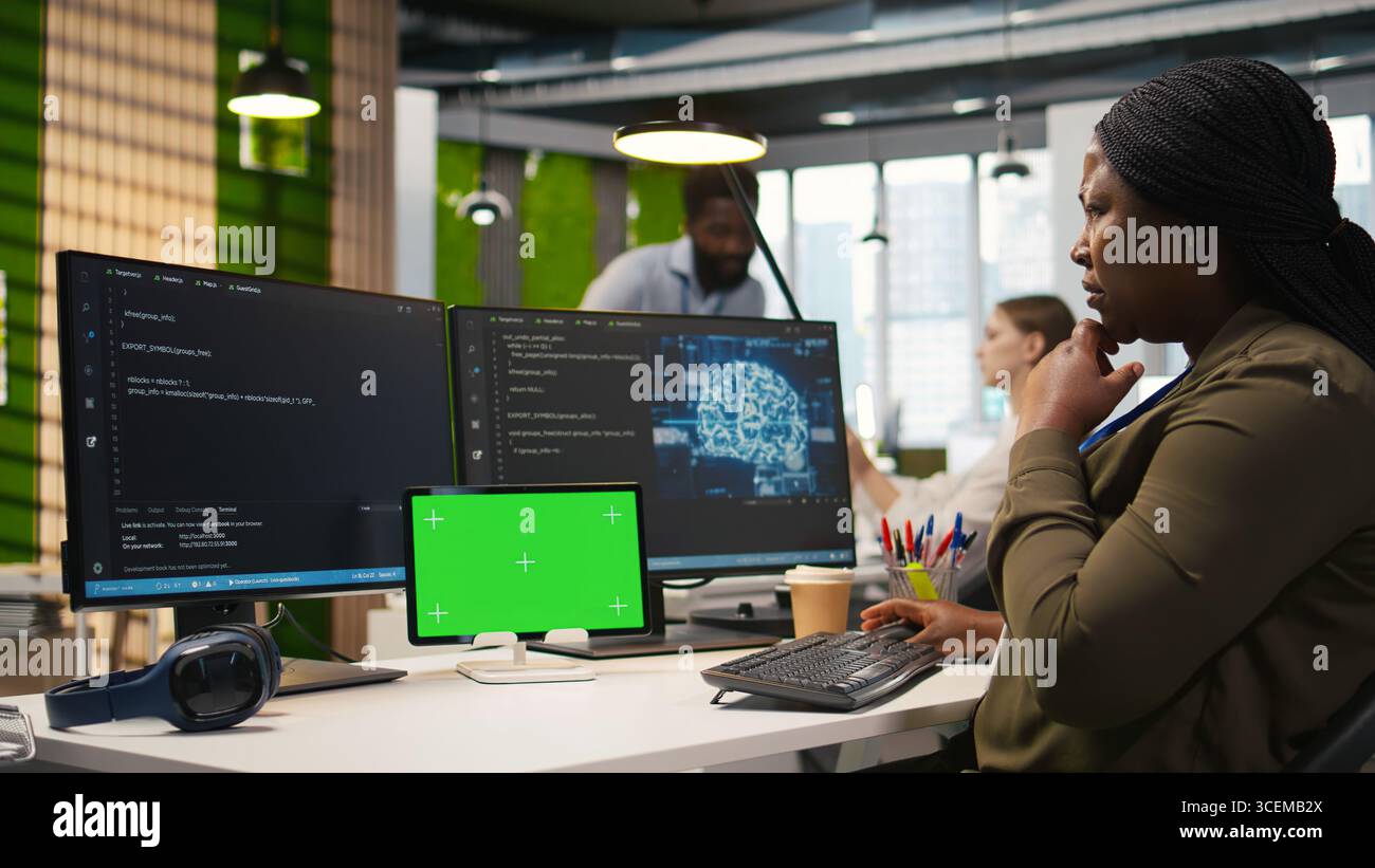 Admin using isolated screen tablet to code AI algorithms debugging software issues and improving system stability. Tech startup office worker using chroma key device, configuring settings, camera A Stock Photo