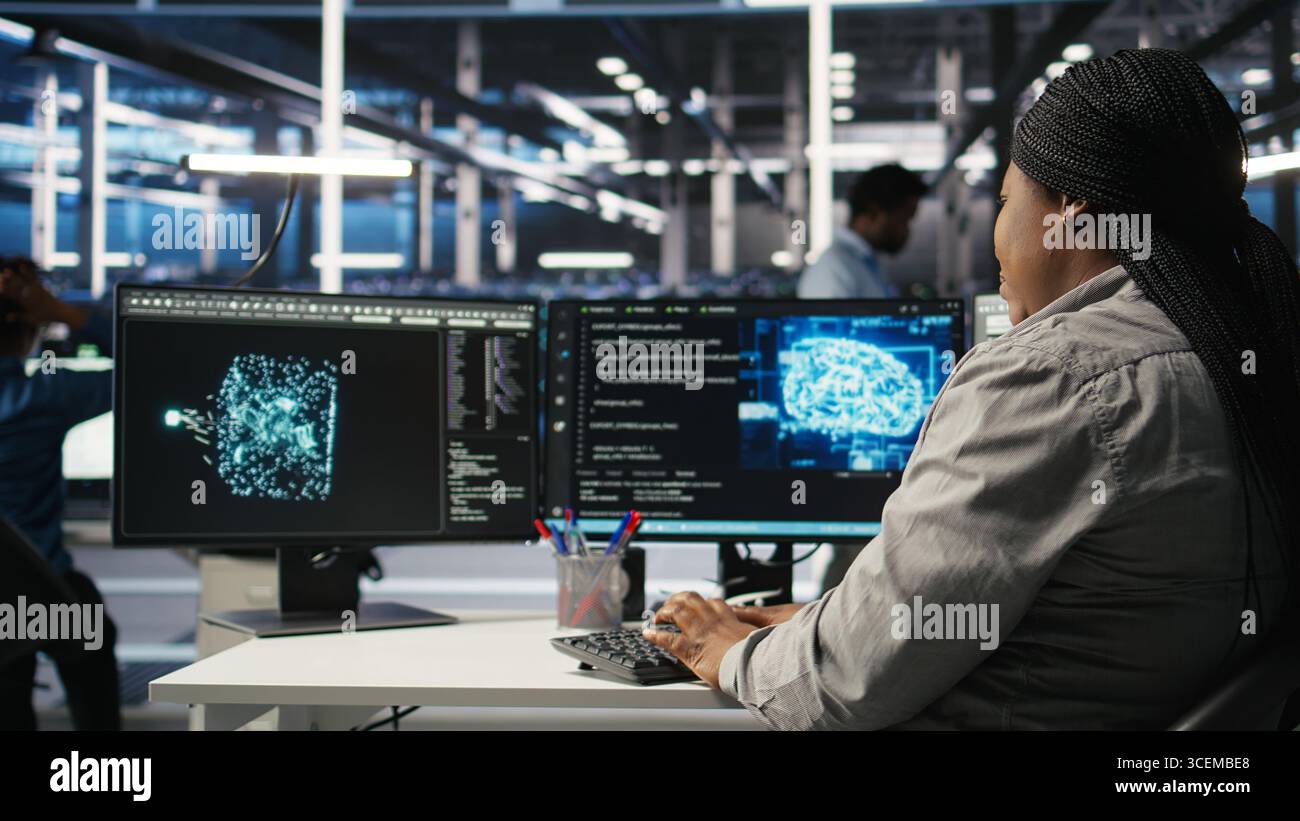 Data center employee deploying AI solutions optimizing equipment. Server farm software developer applying artificial intelligence technology minimizing infrastructure downtime, camera A Stock Photo