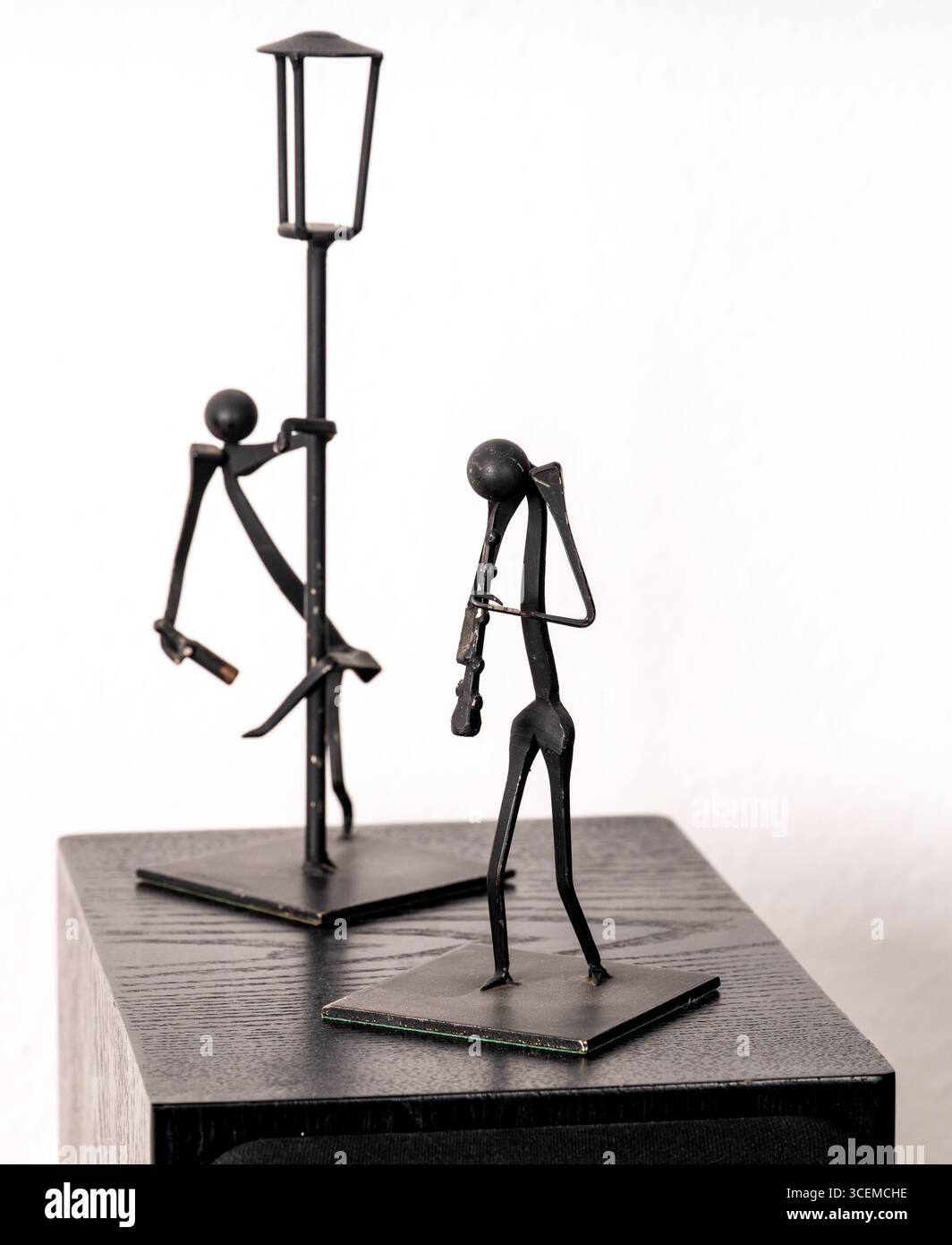 Two wire frame metal pieces of art - a clarinet player and a drunk, against a white background. Stock Photo