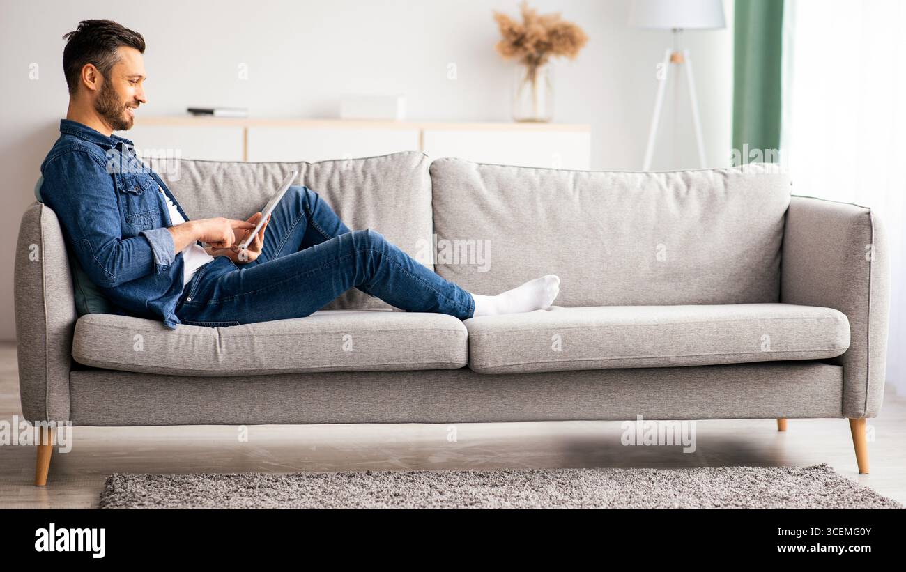 Handsome bearded man using digital tablet at home Stock Photo