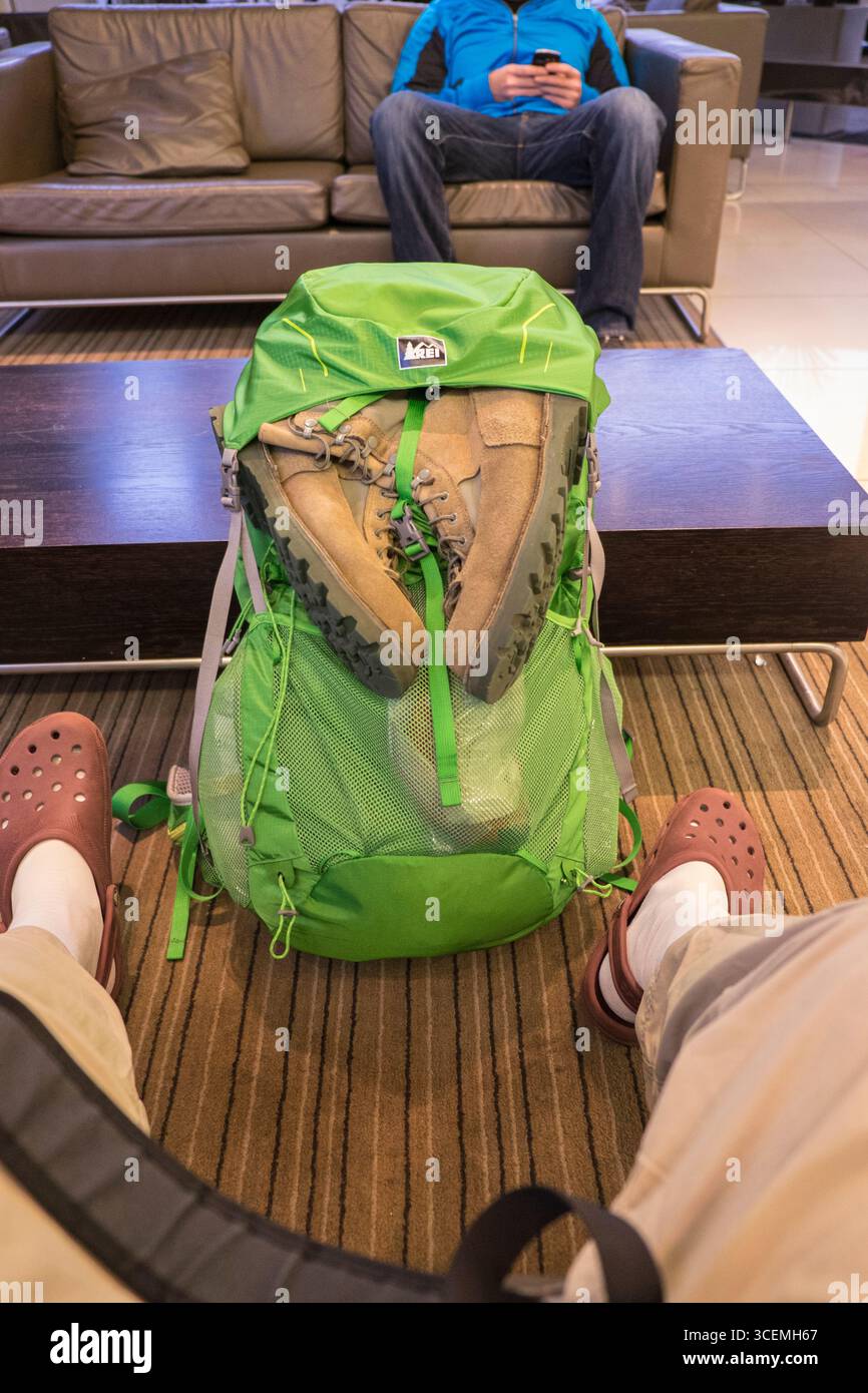 Boots tied to green backpack inside hotel lobby, Queenstown, Otago, South Island, New Zealand Stock Photo