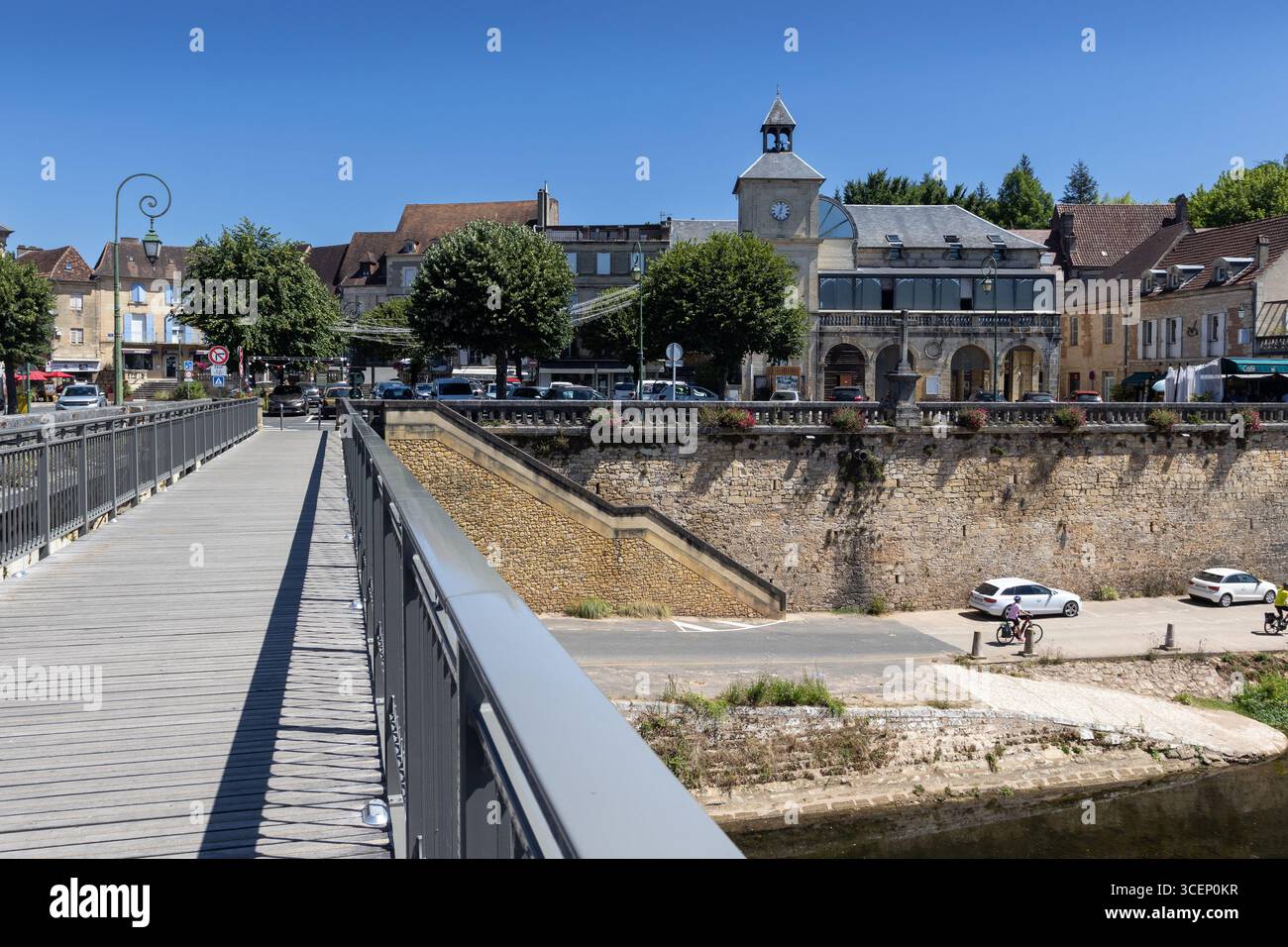 View of the town center of Le Bugue from the foot bridge over the Vézère River. Town Hall on the right. Le Bugue is a popular tourist destination in t - Stock Image
